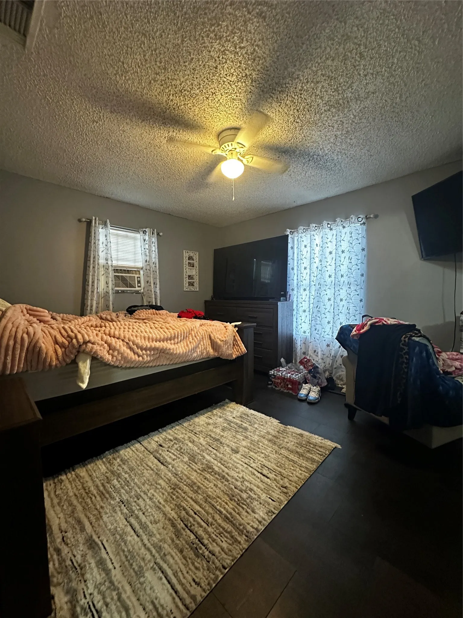 Bedroom featuring a ceiling fan with integrated lighting, and a window