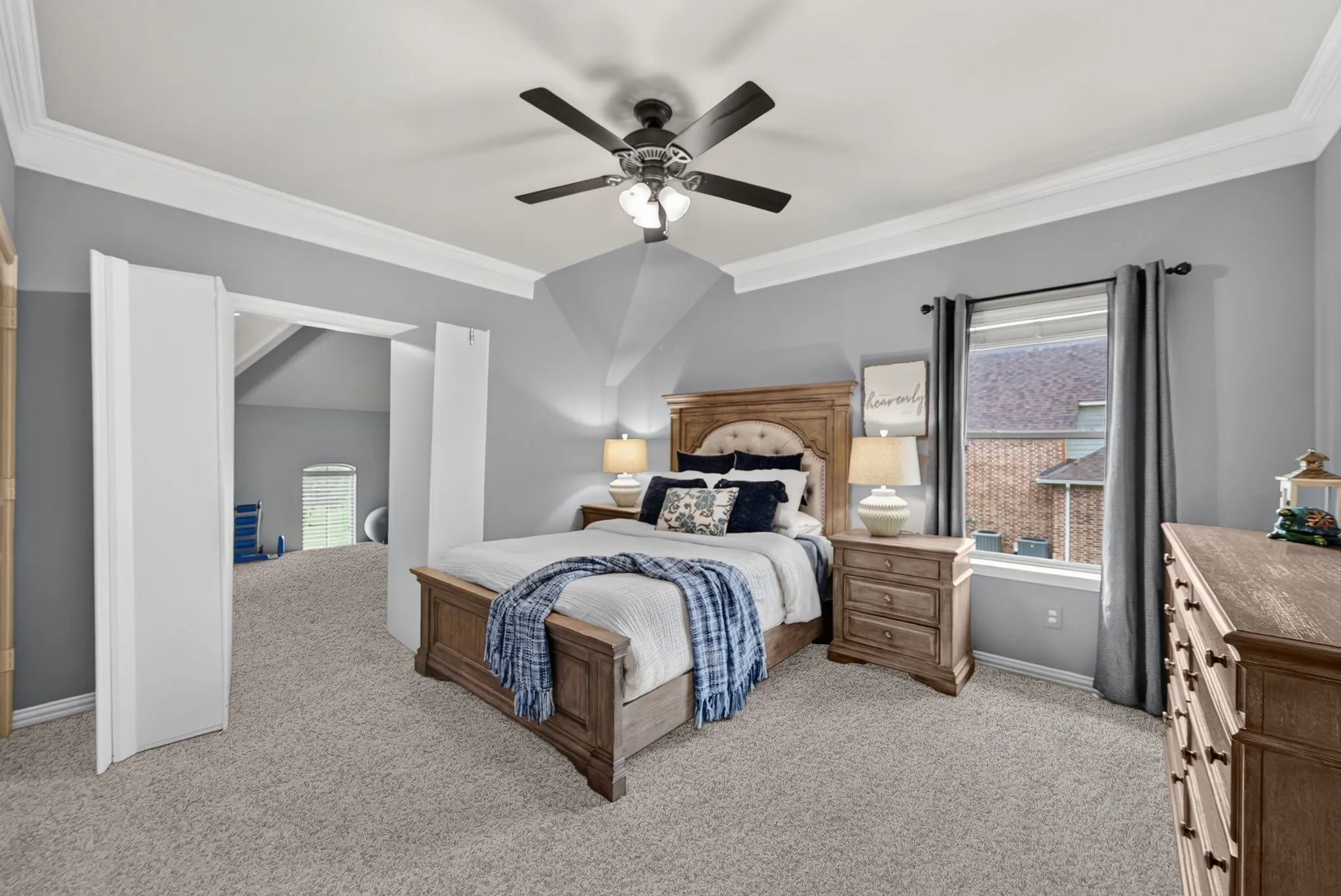Carpeted room with crown molding, a ceiling fan, and a window with blinds
