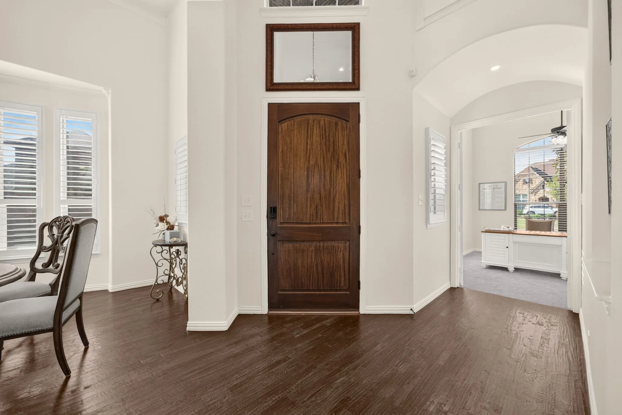 Warm wood-finish flooring, a solid wood entry door, and tall ceilings
