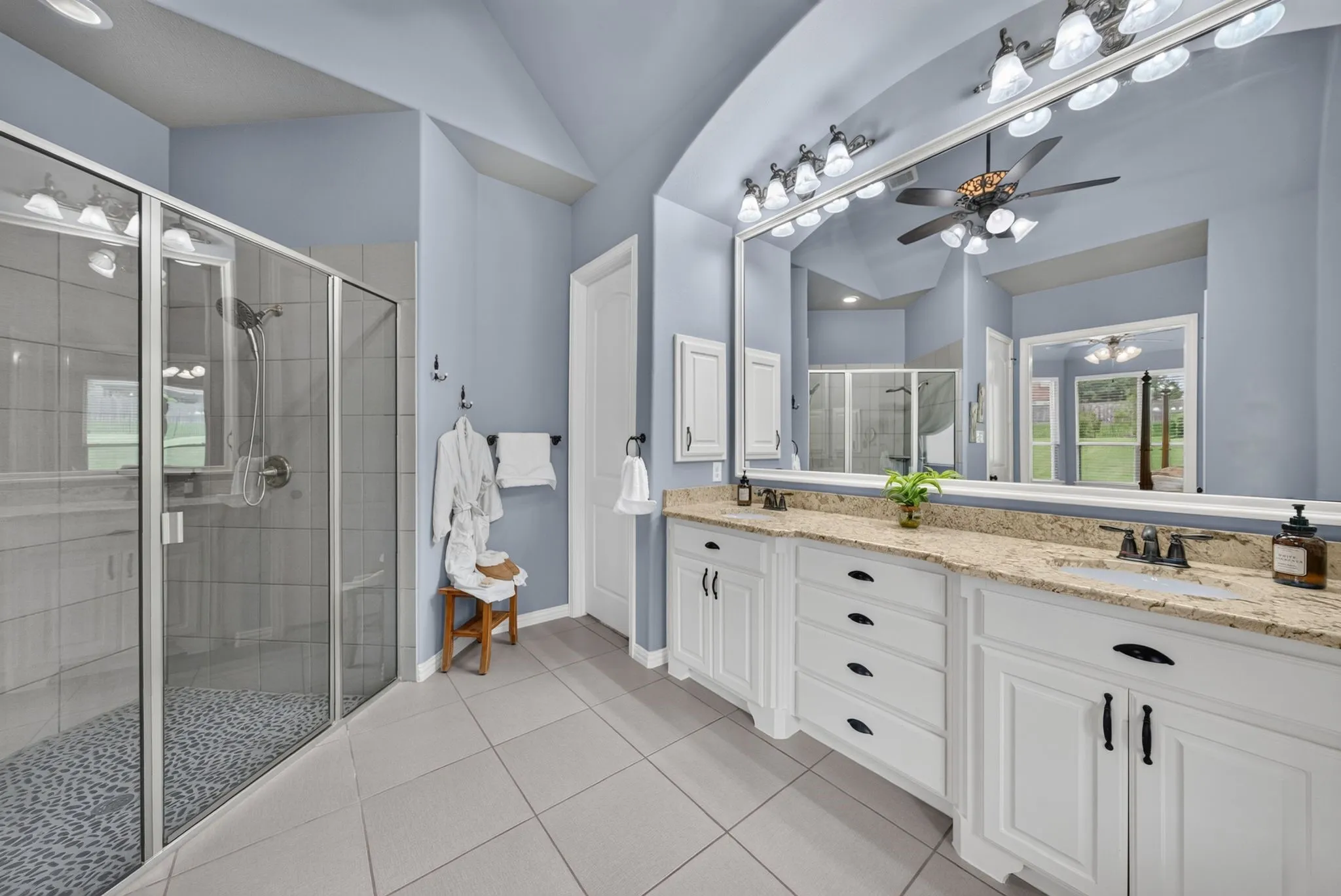 Dual vanity with granite countertops, undermount sinks, and white cabinetry