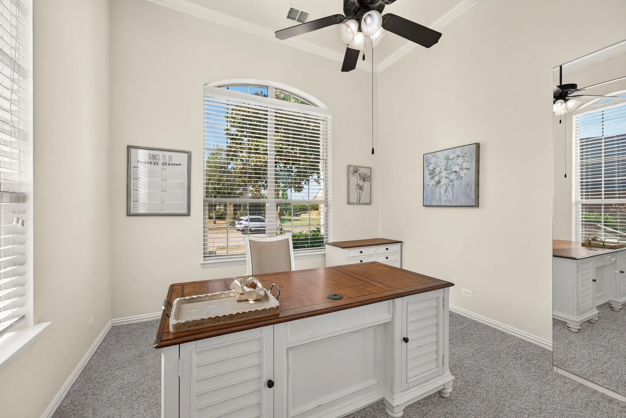 Arched window with blinds, vaulted ceiling, crown molding, and ceiling fan
