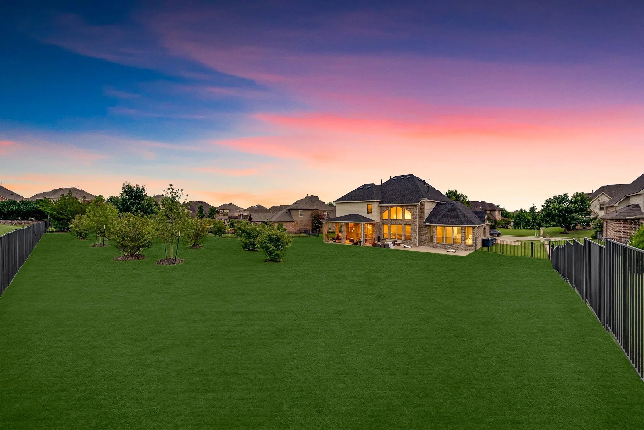 Expansive rear yard featuring a manicured lawn and mature landscaping