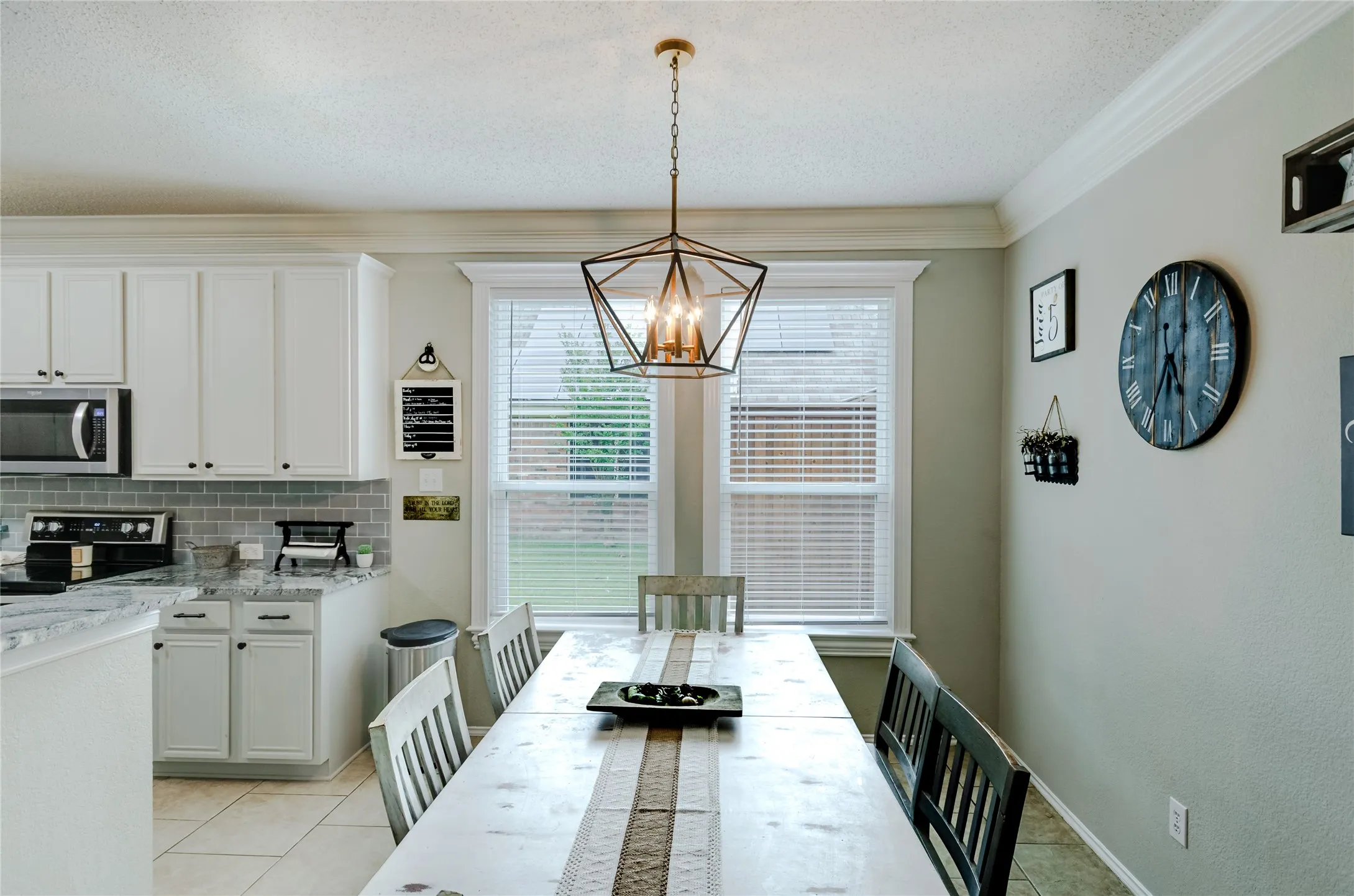 Dining area with a geometric chandelier and crown molding
