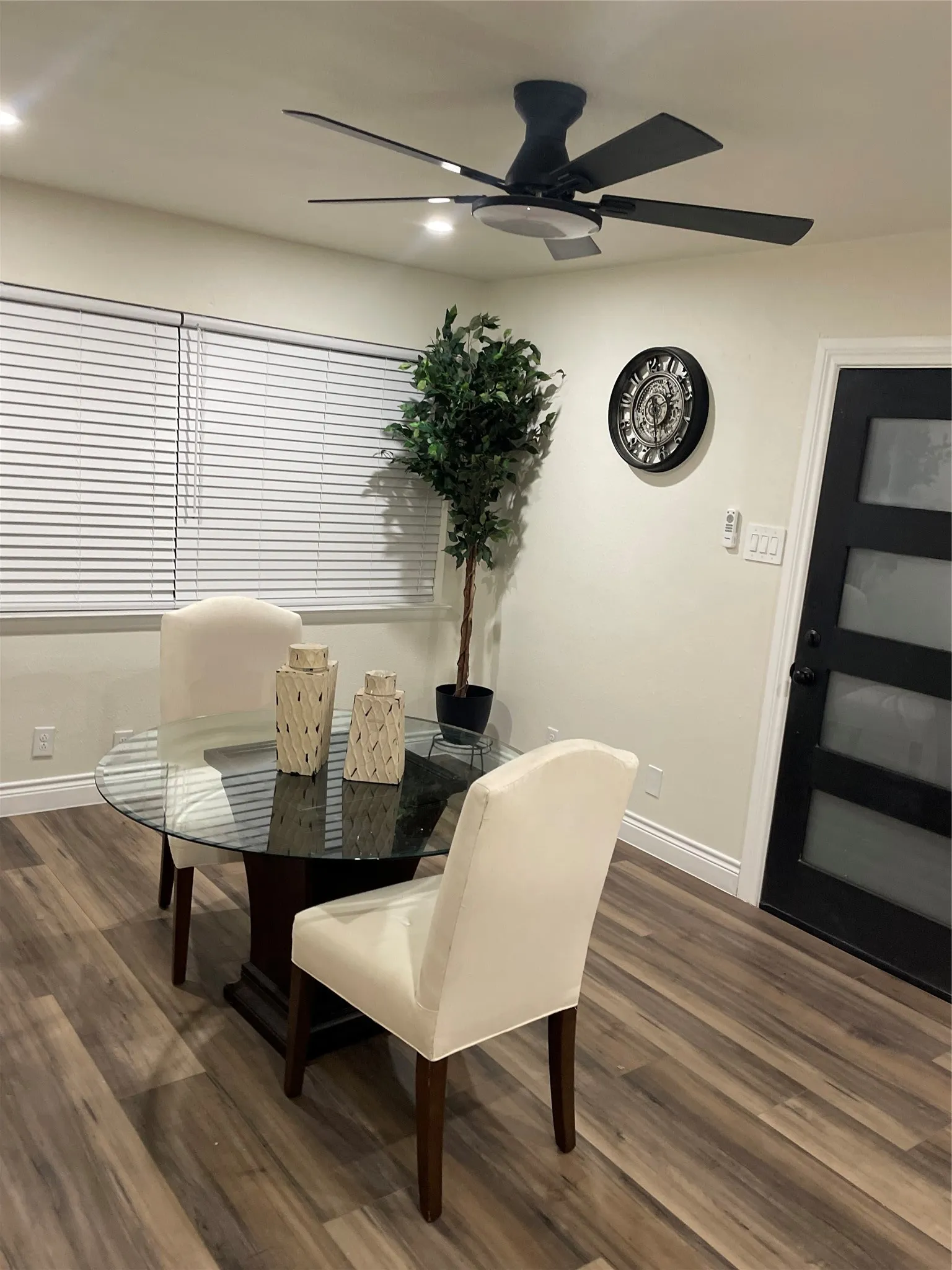 Spacious room featuring wood-finish flooring, a contemporary ceiling fan with integrated lighting, and recessed ceiling lights