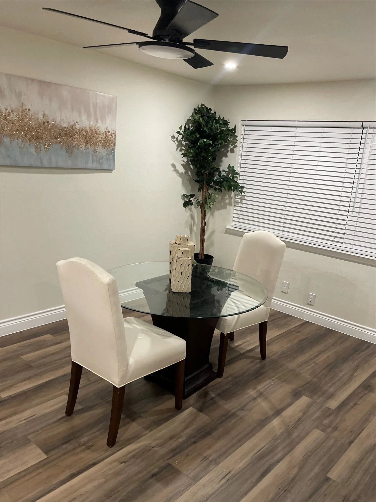 Spacious room featuring wood-finish flooring, a contemporary ceiling fan with integrated lighting, and recessed ceiling lighting