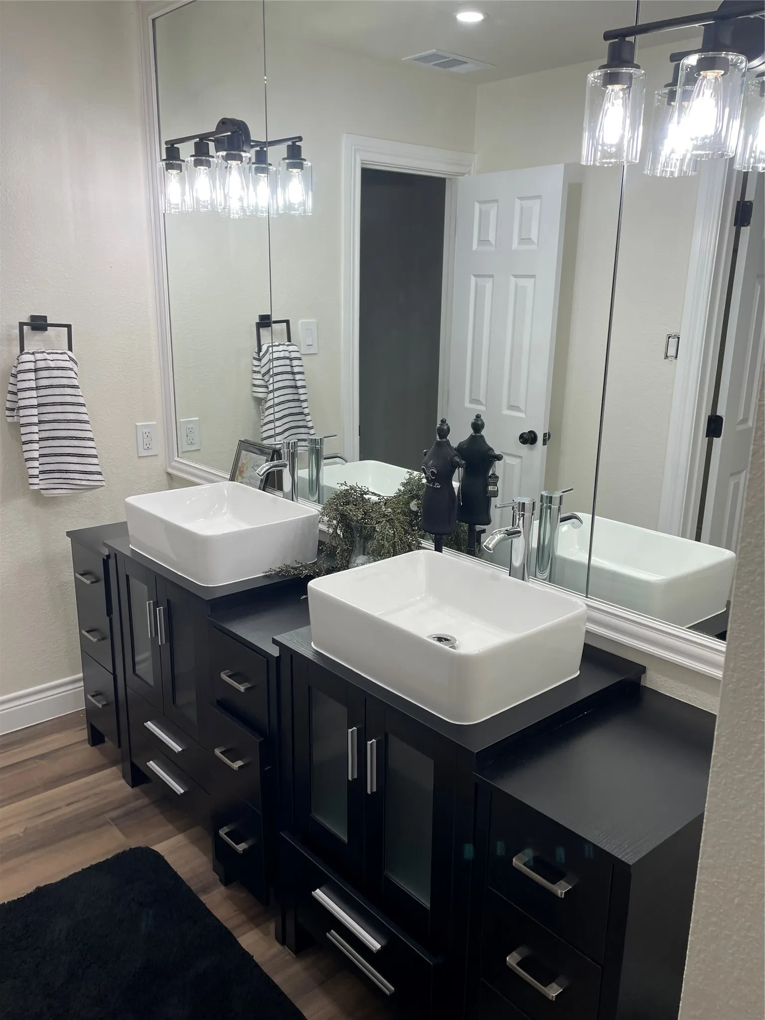 Dual rectangular vessel sinks atop dark wood-finish vanities with ample storage