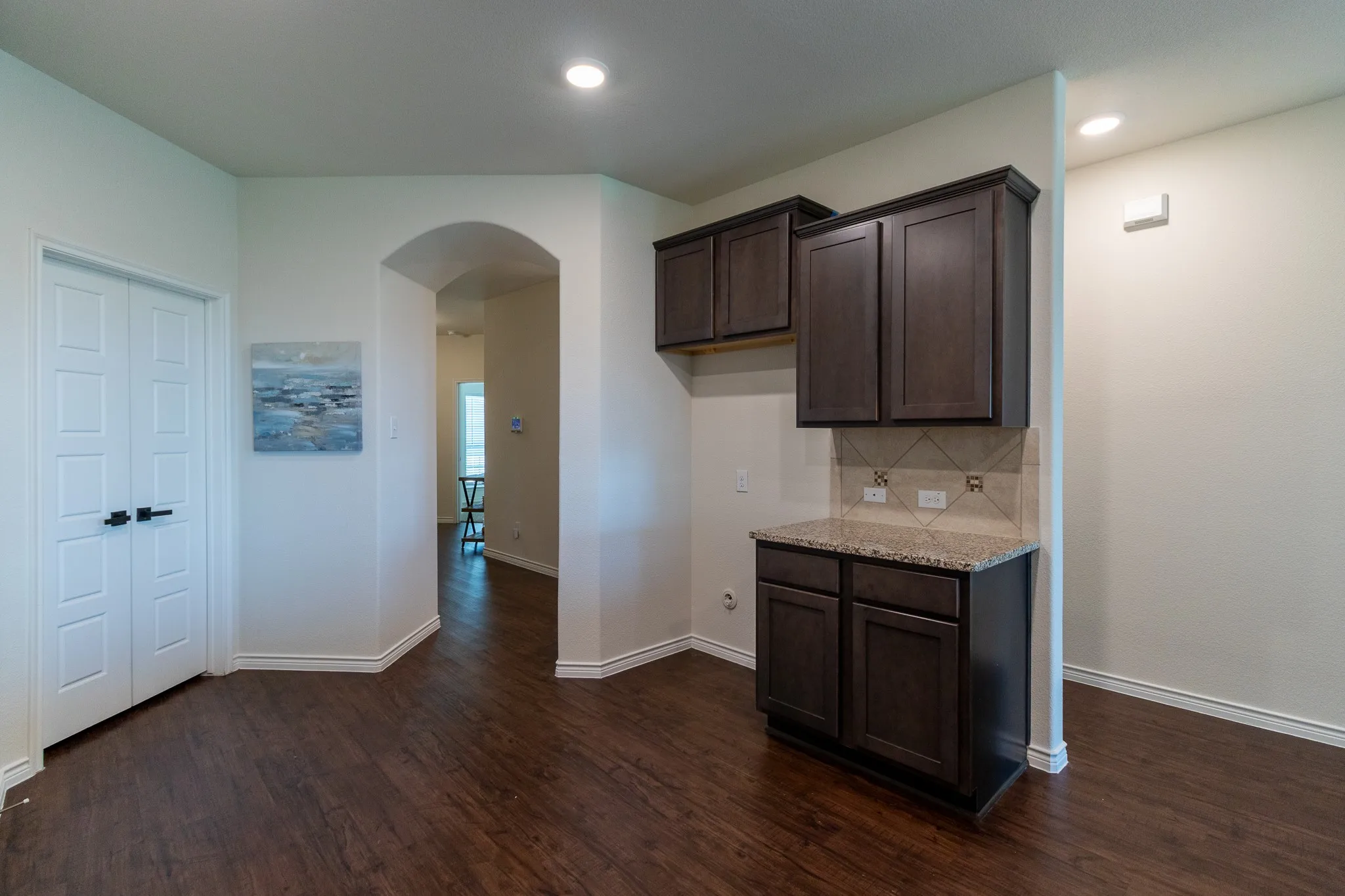 Built-in cabinetry with a granite-style countertop and tile backsplash