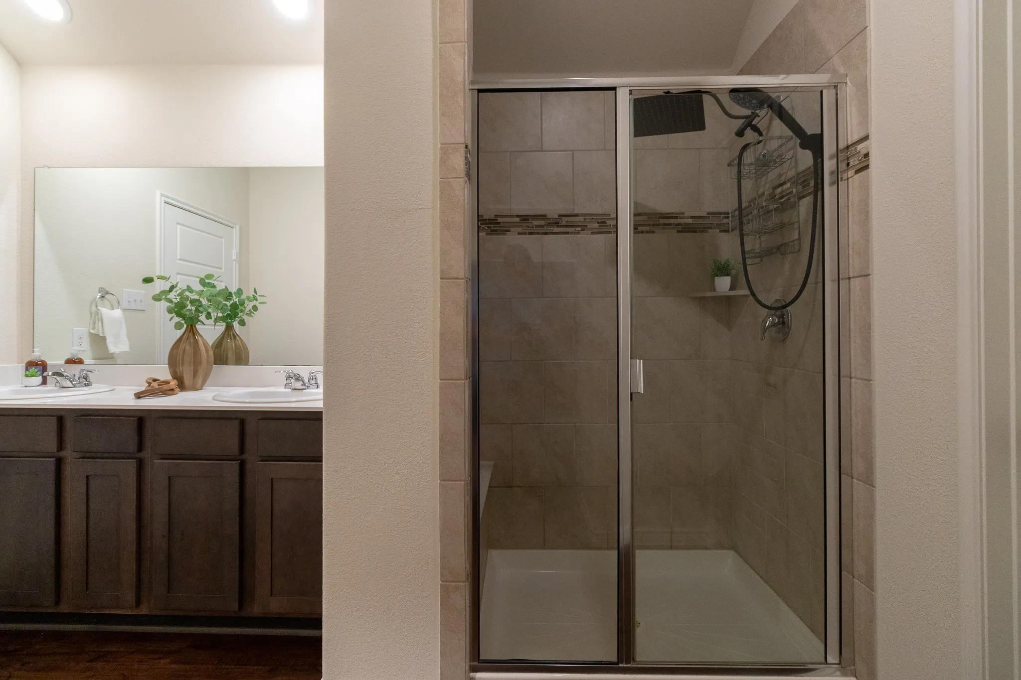 Bathroom featuring a dual vanity with dark wood cabinetry and a large mirror
