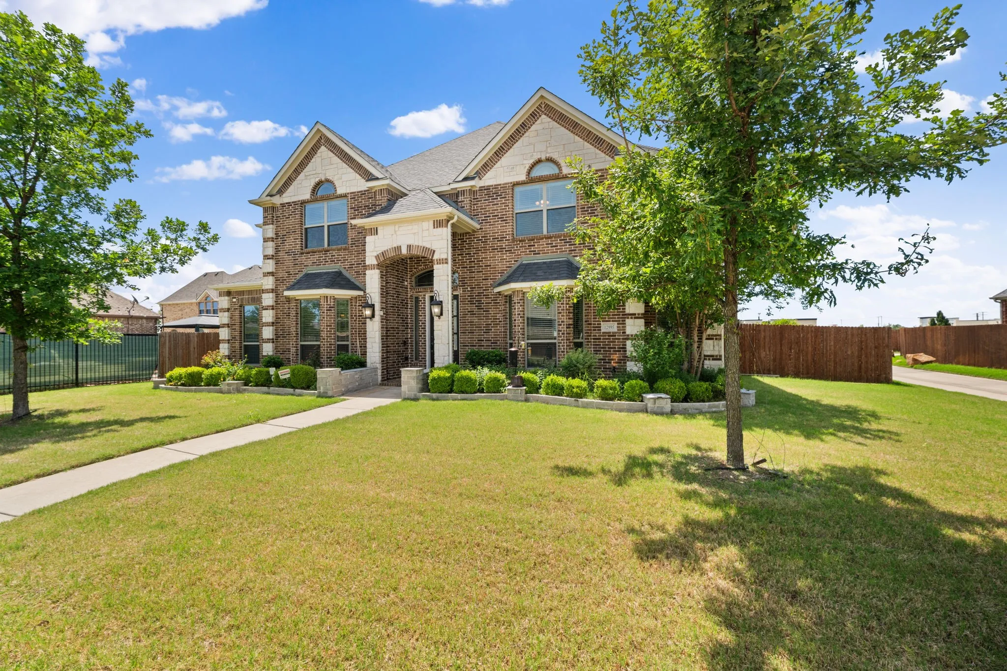 Traditional brick and stone facade home featuring a gabled roofline