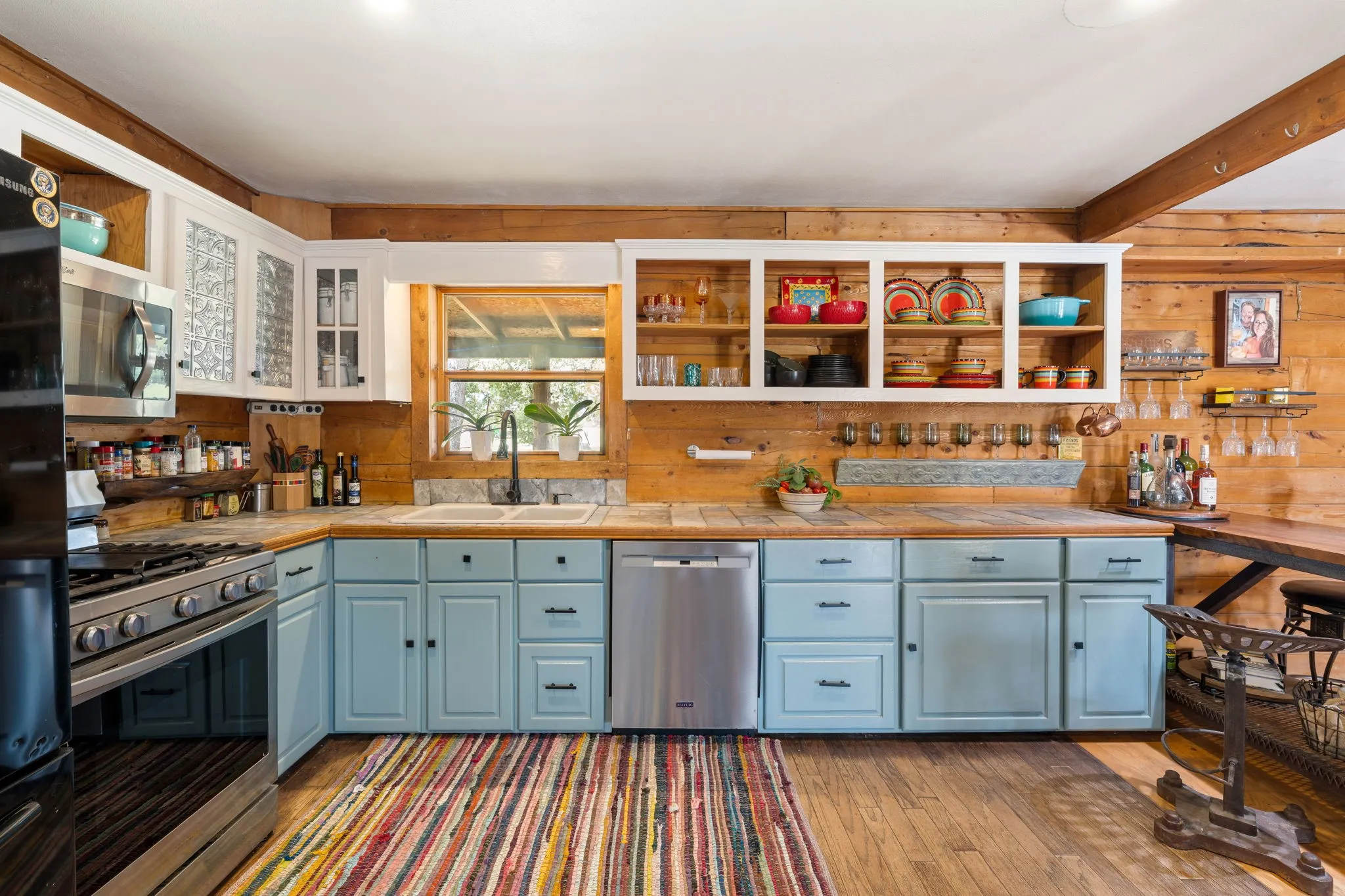 Kitchen featuring wood-finish flooring, a stainless steel range, and a stainless steel dishwasher