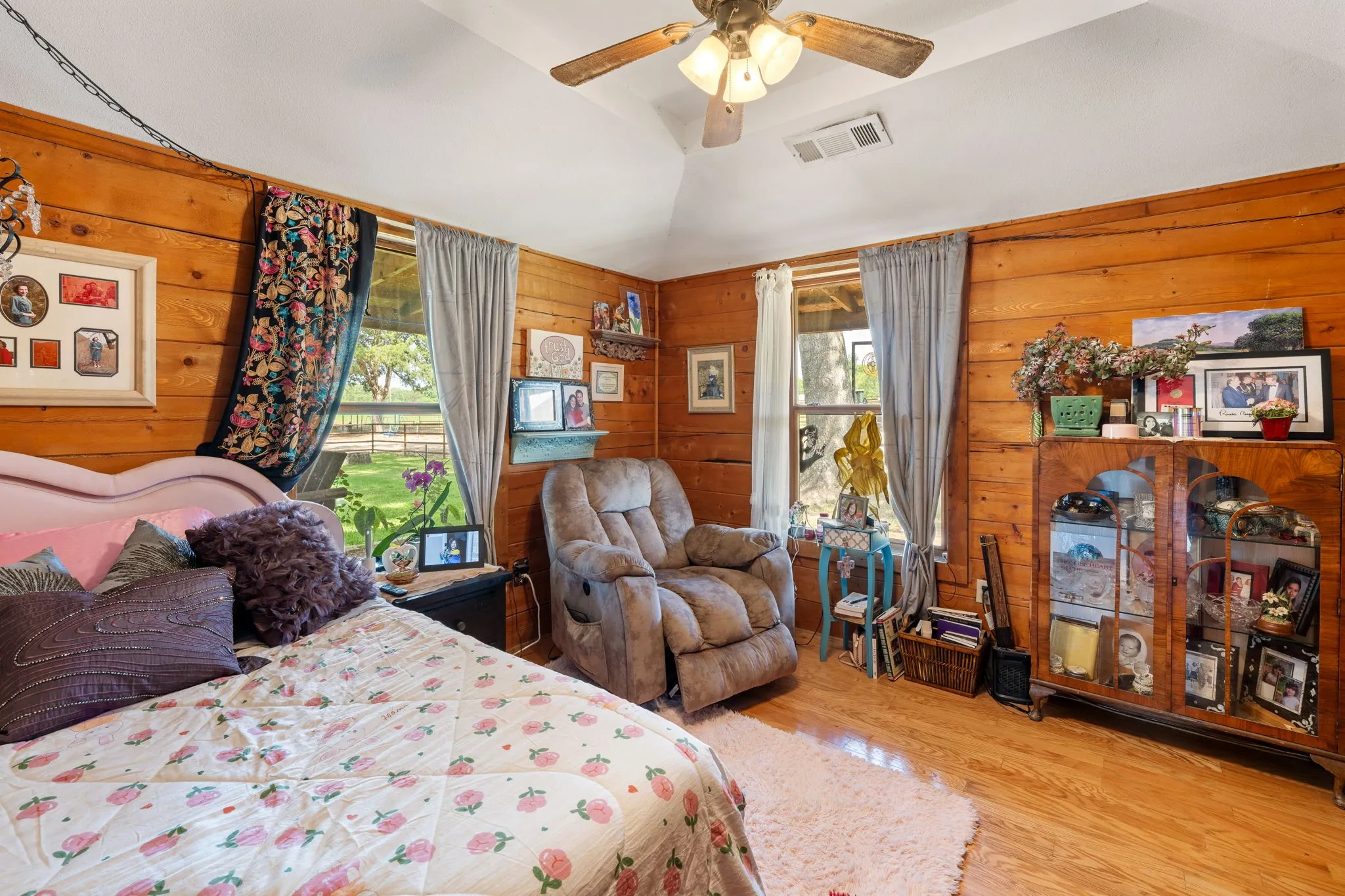 Room with wood-finish paneling, wood-finish flooring, and a vaulted ceiling