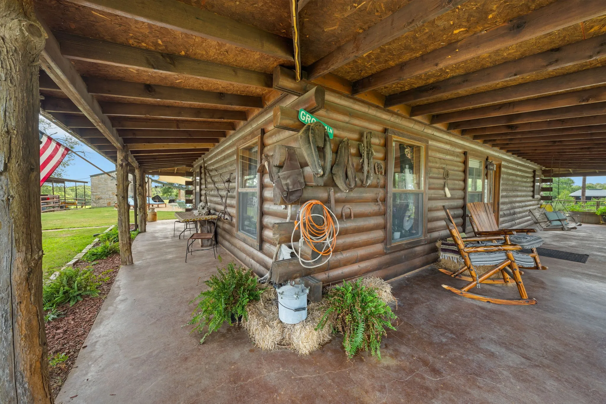 Expansive wrap-around porch featuring a stained concrete floor and natural wood posts