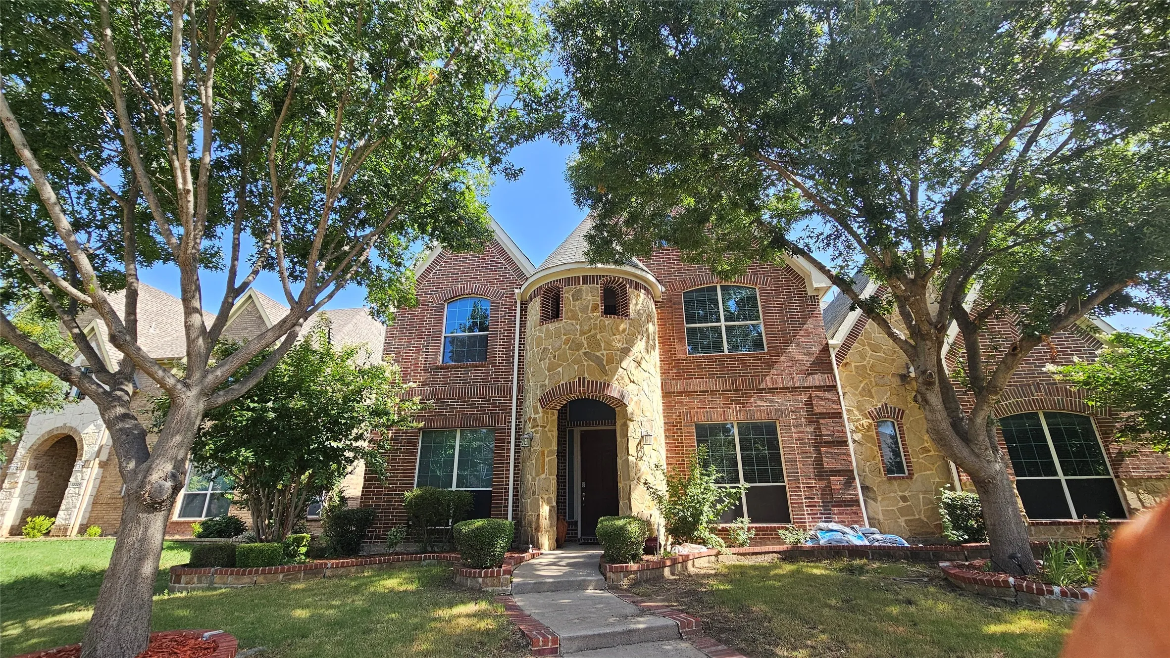 Brick and stone exterior featuring a turret-style entry