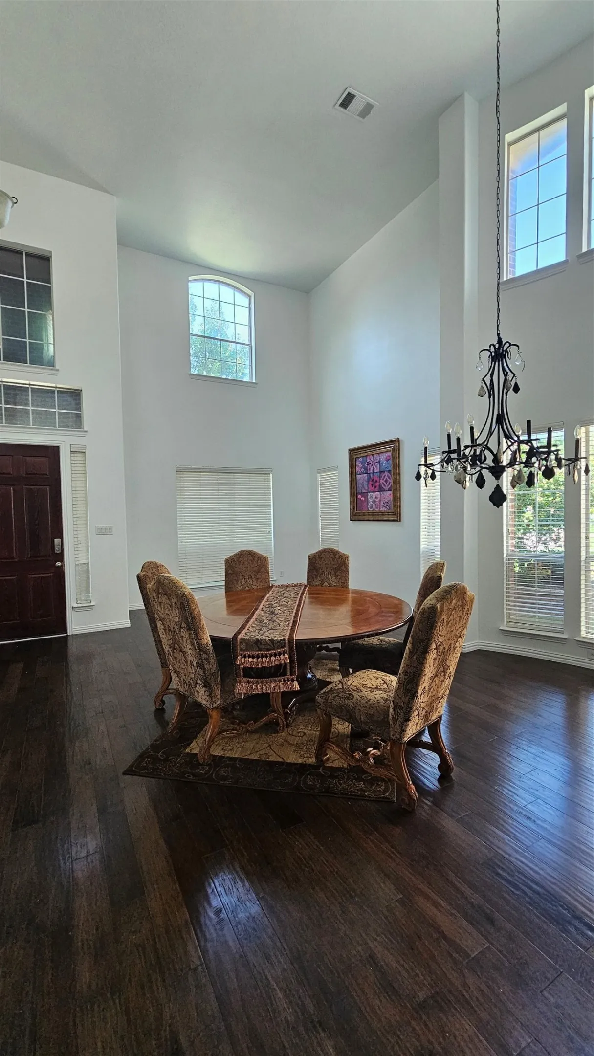 Spacious interior featuring high ceilings, dark wood-finish flooring, and multiple windows