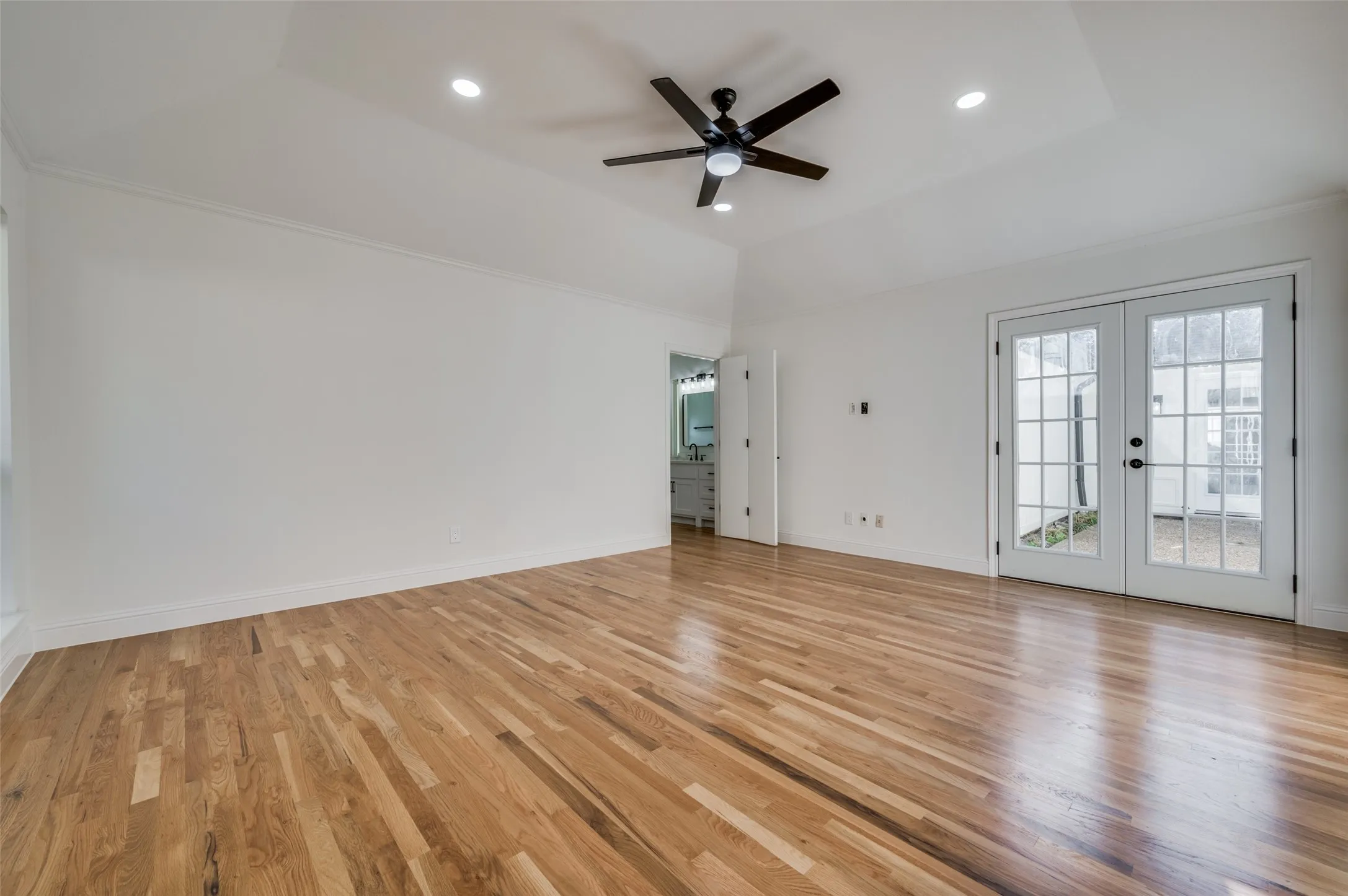 French doors lead from primary bedroom to courtyard area