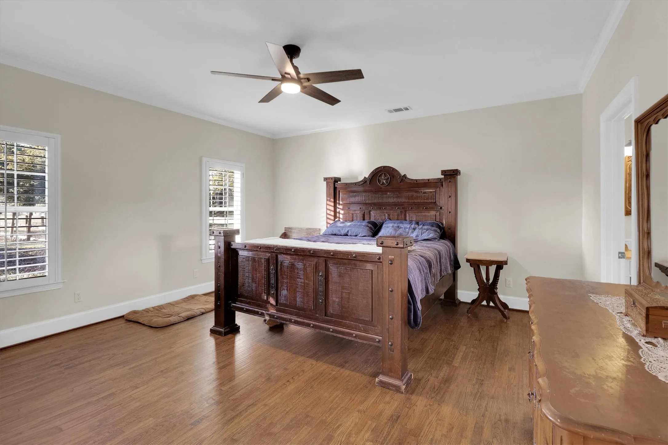 Bedroom with wood finished floors, ornamental molding, and ceiling fan