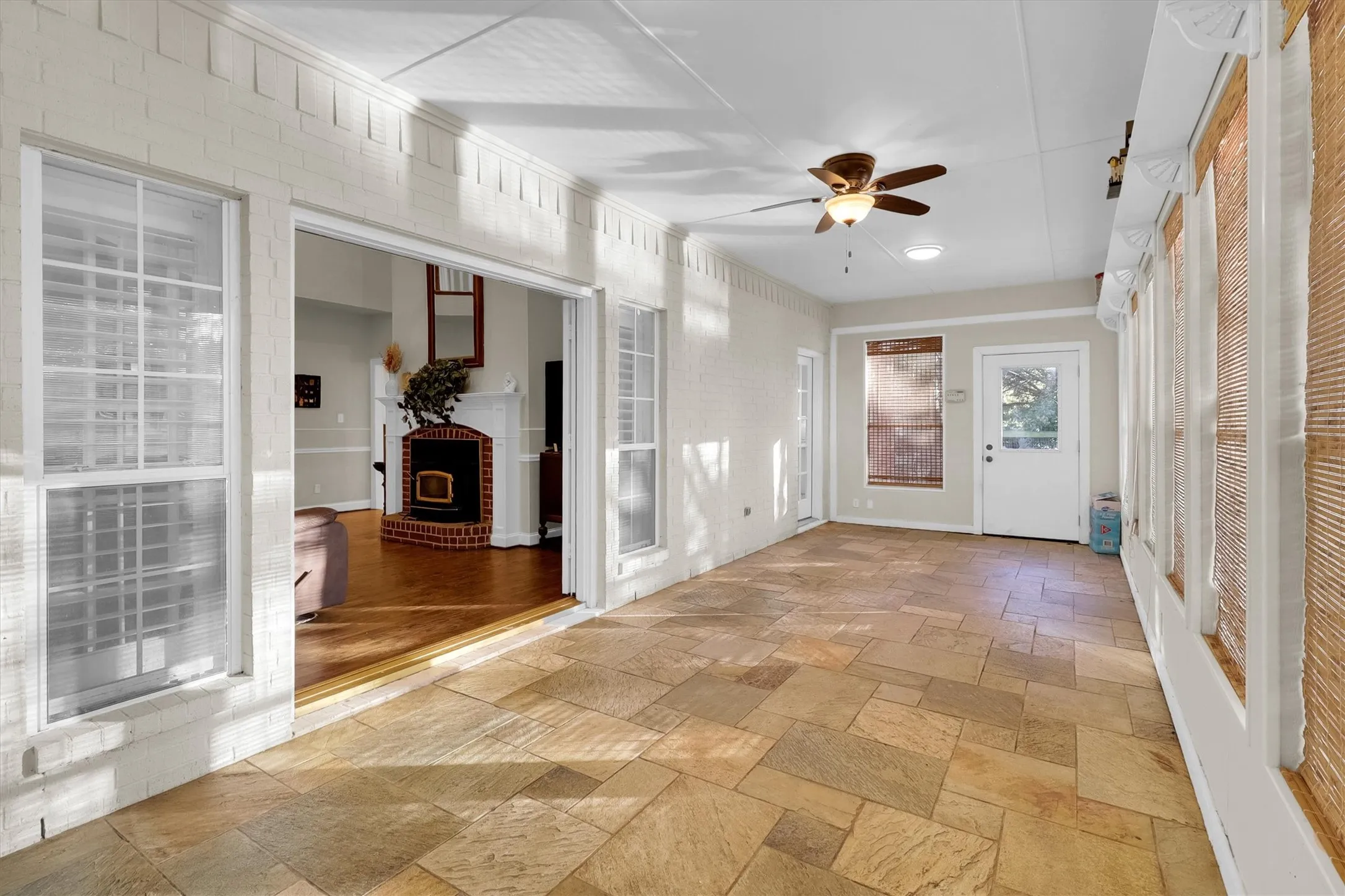 Entrance foyer featuring ceiling fan and stone tile floors