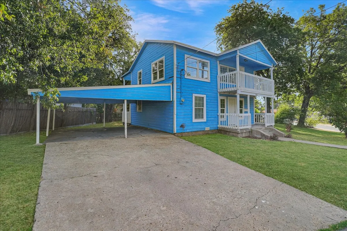 Blue exterior with white trim, featuring a two-story covered balcony with white railings