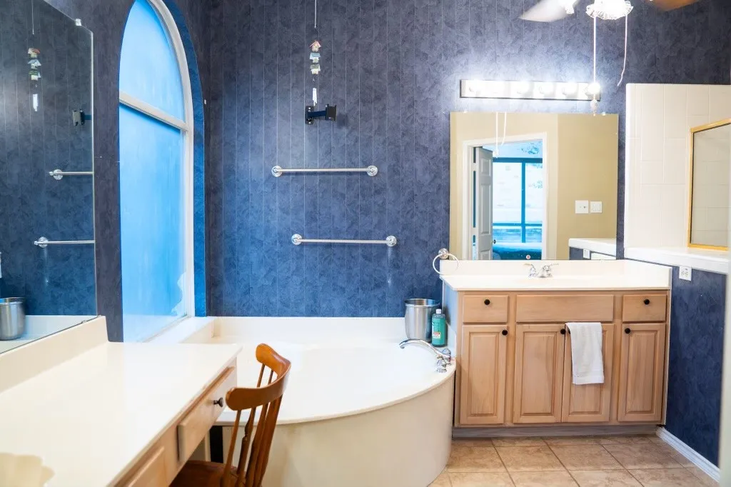 Bathroom featuring a built-in soaking tub and an arched frosted window