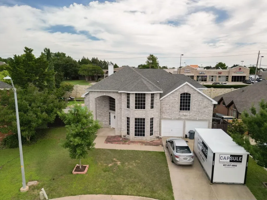 Two-story brick exterior featuring a multi-gable roofline and an arched entry