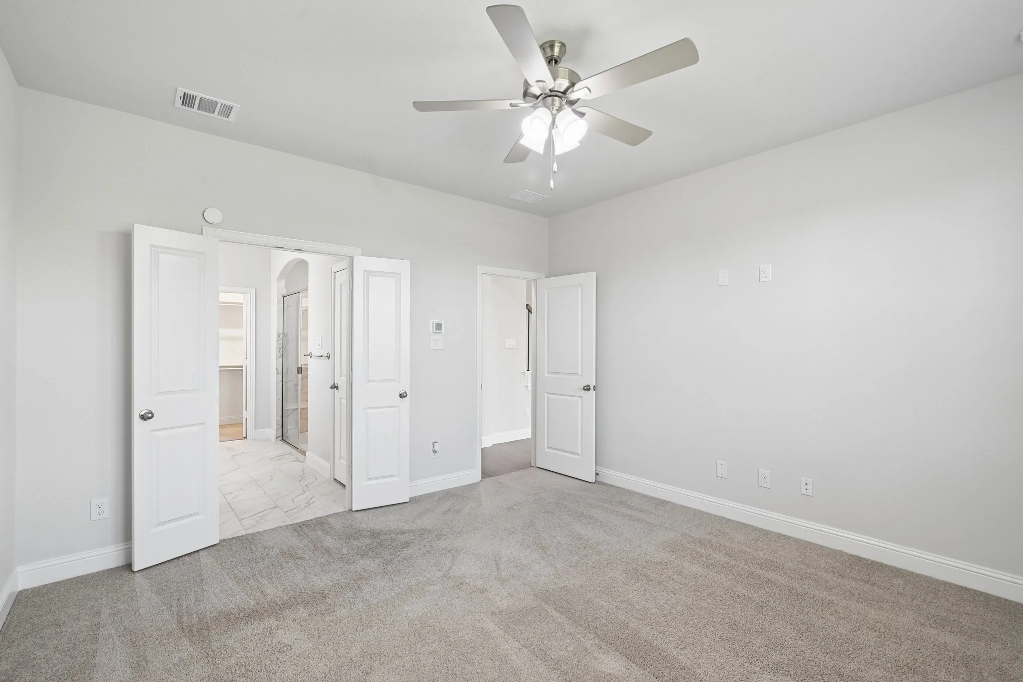 Spacious room featuring neutral carpeting and light gray walls