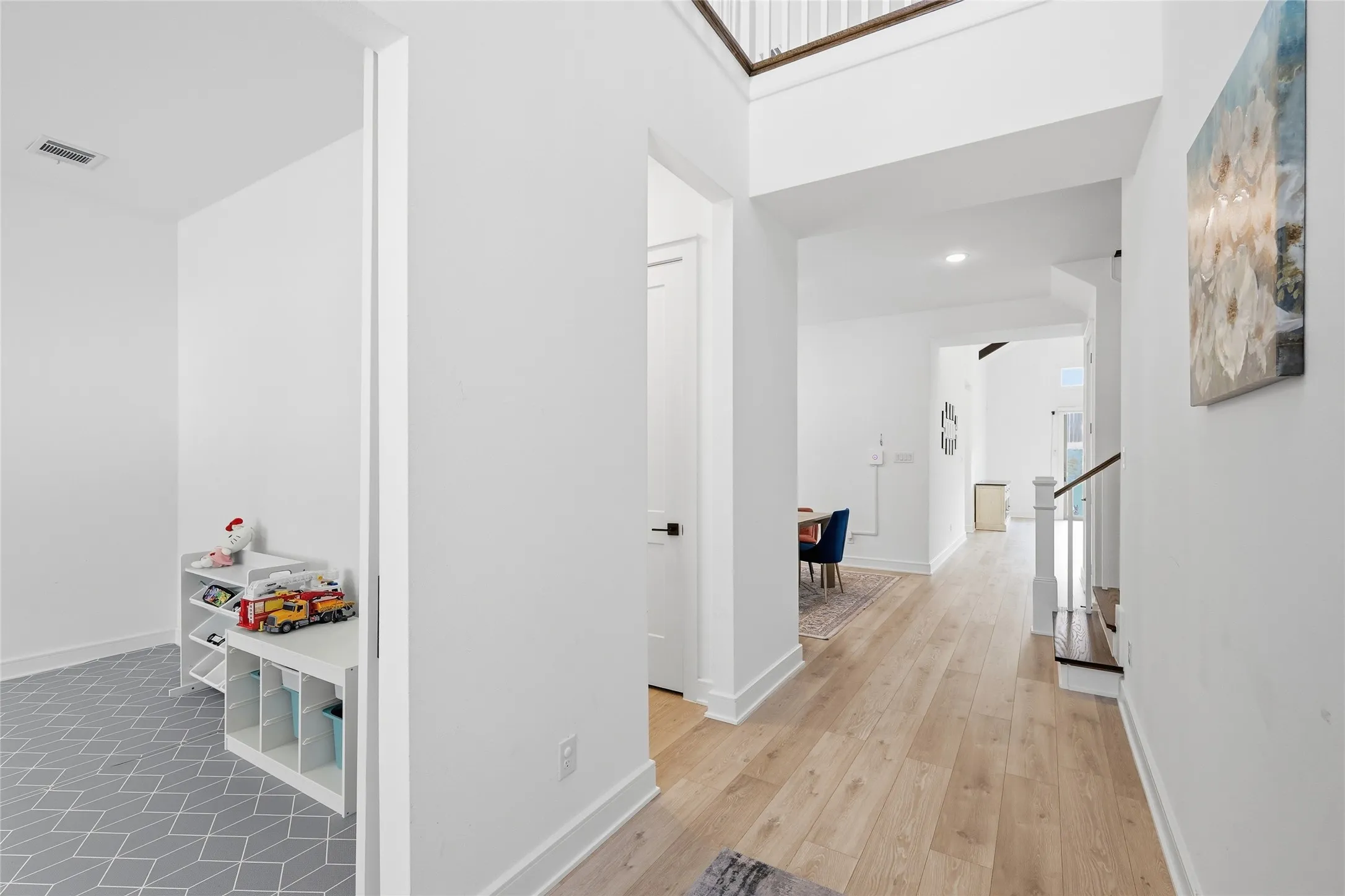 Main hallway featuring wood-finish flooring and a staircase with dark wood treads and white risers