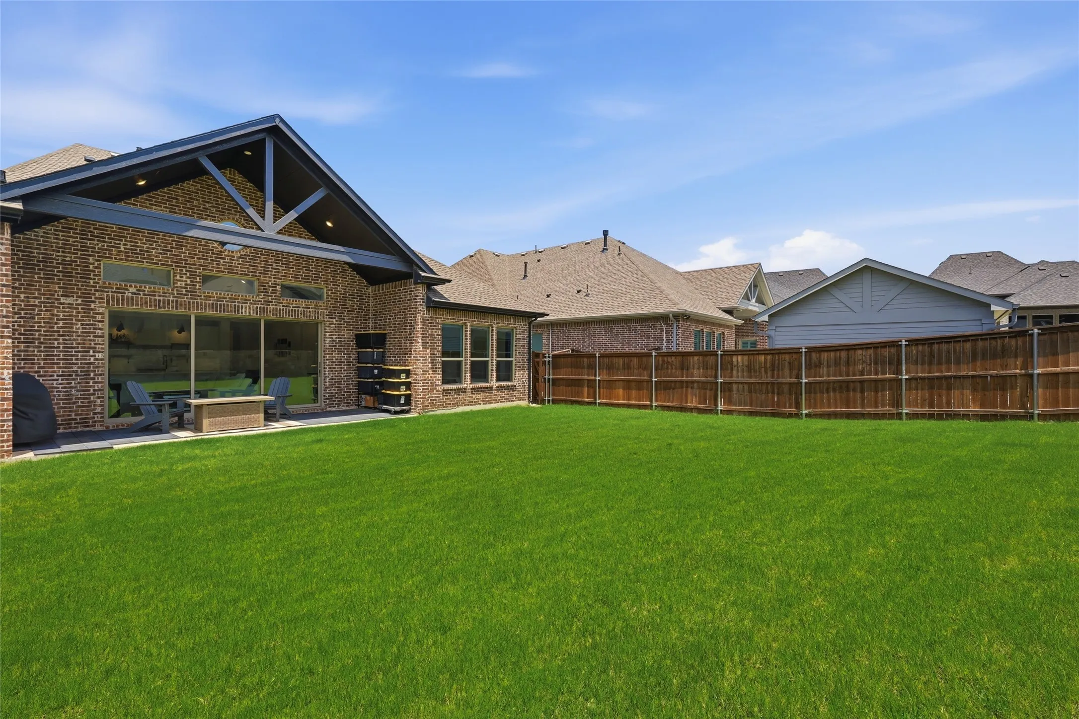Expansive green lawn with a full privacy fence