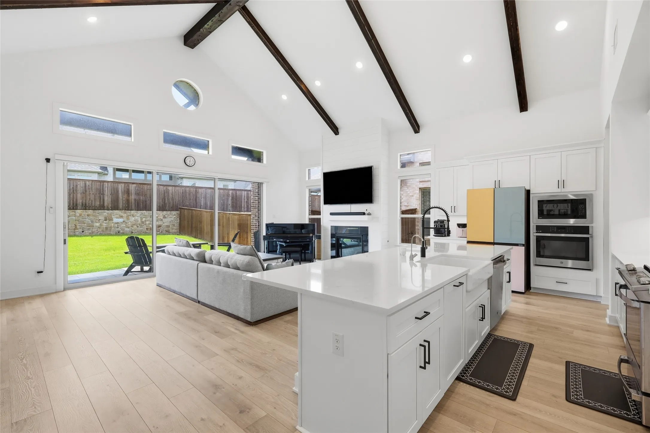 Vaulted ceilings with exposed beams complement the open-concept living space and kitchen