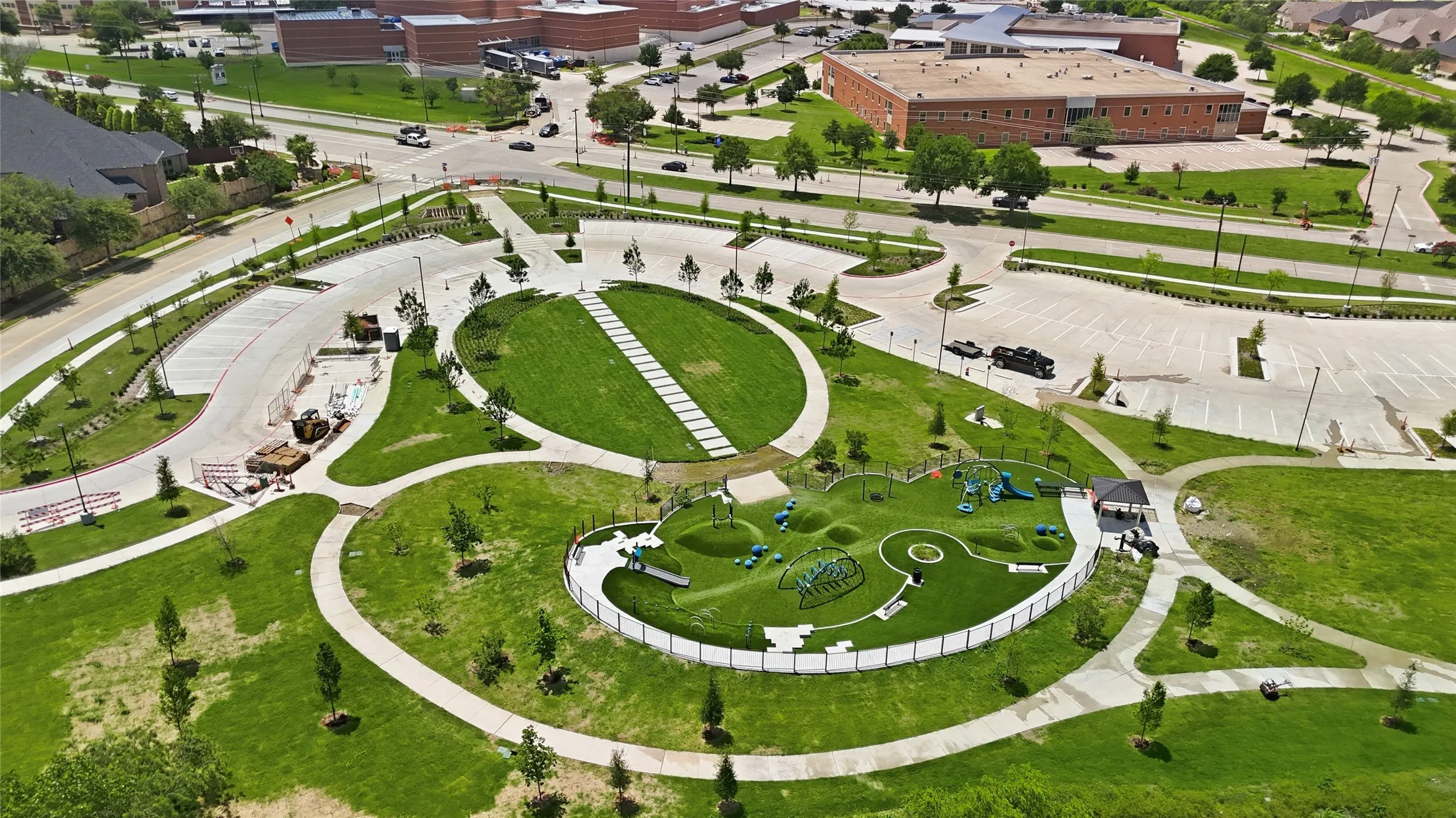 Aerial view showcasing a community park with a children's play area, walking paths, and expansive green spaces