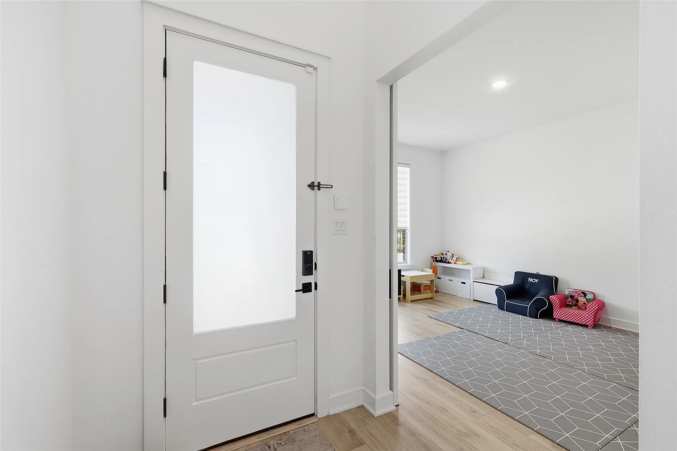 White interior door with frosted glass panel and dark hardware