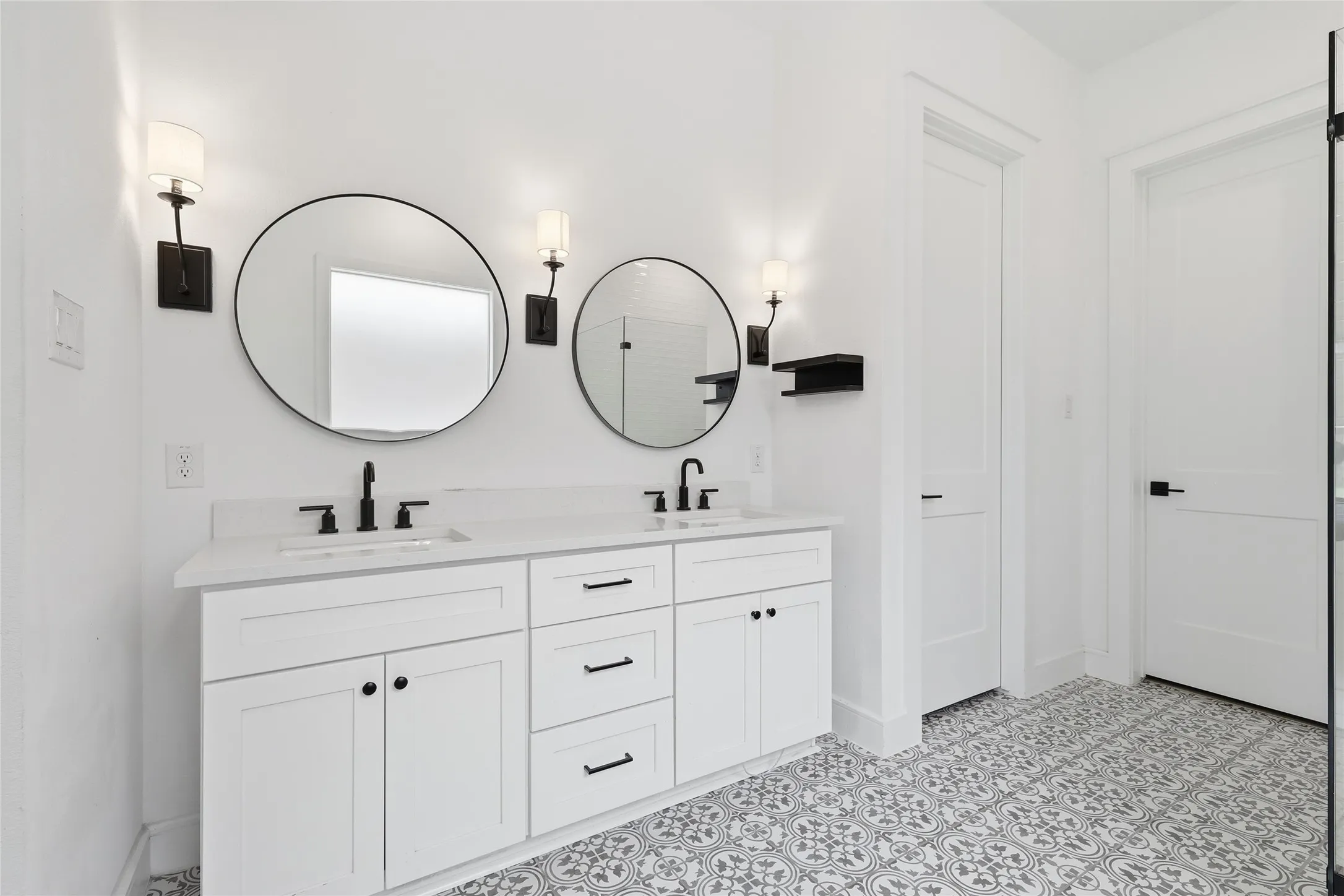 Dual vanity featuring a white countertop, matte black fixtures, and two circular mirrors