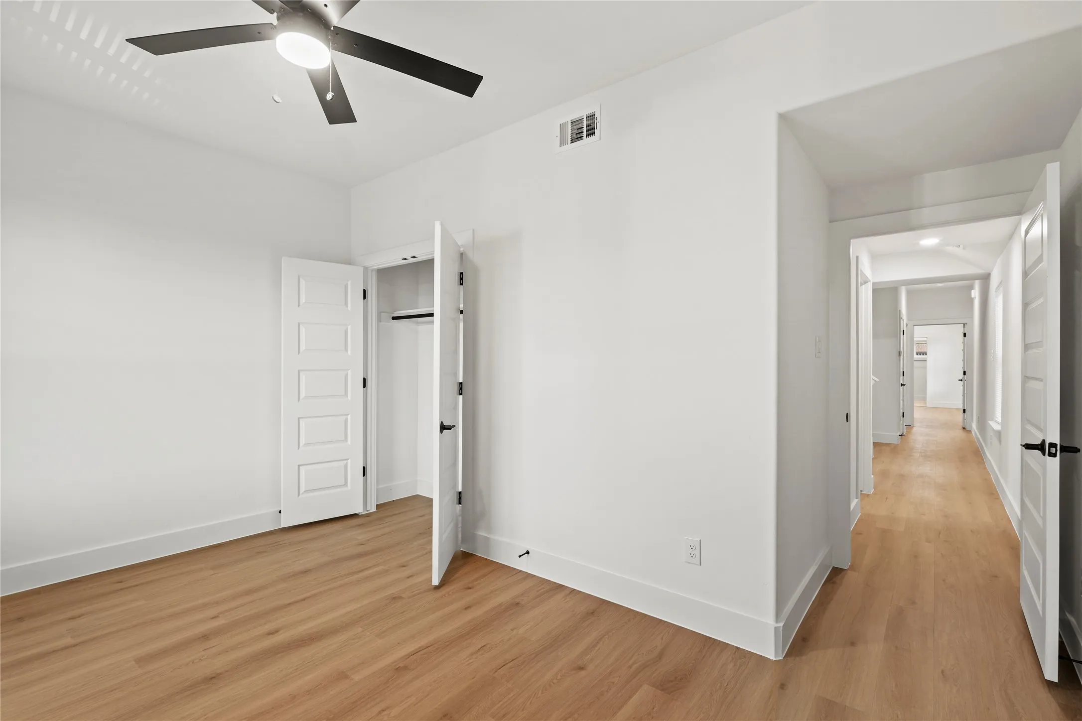 Unfurnished bedroom with ceiling fan and light hardwood / wood-style flooring