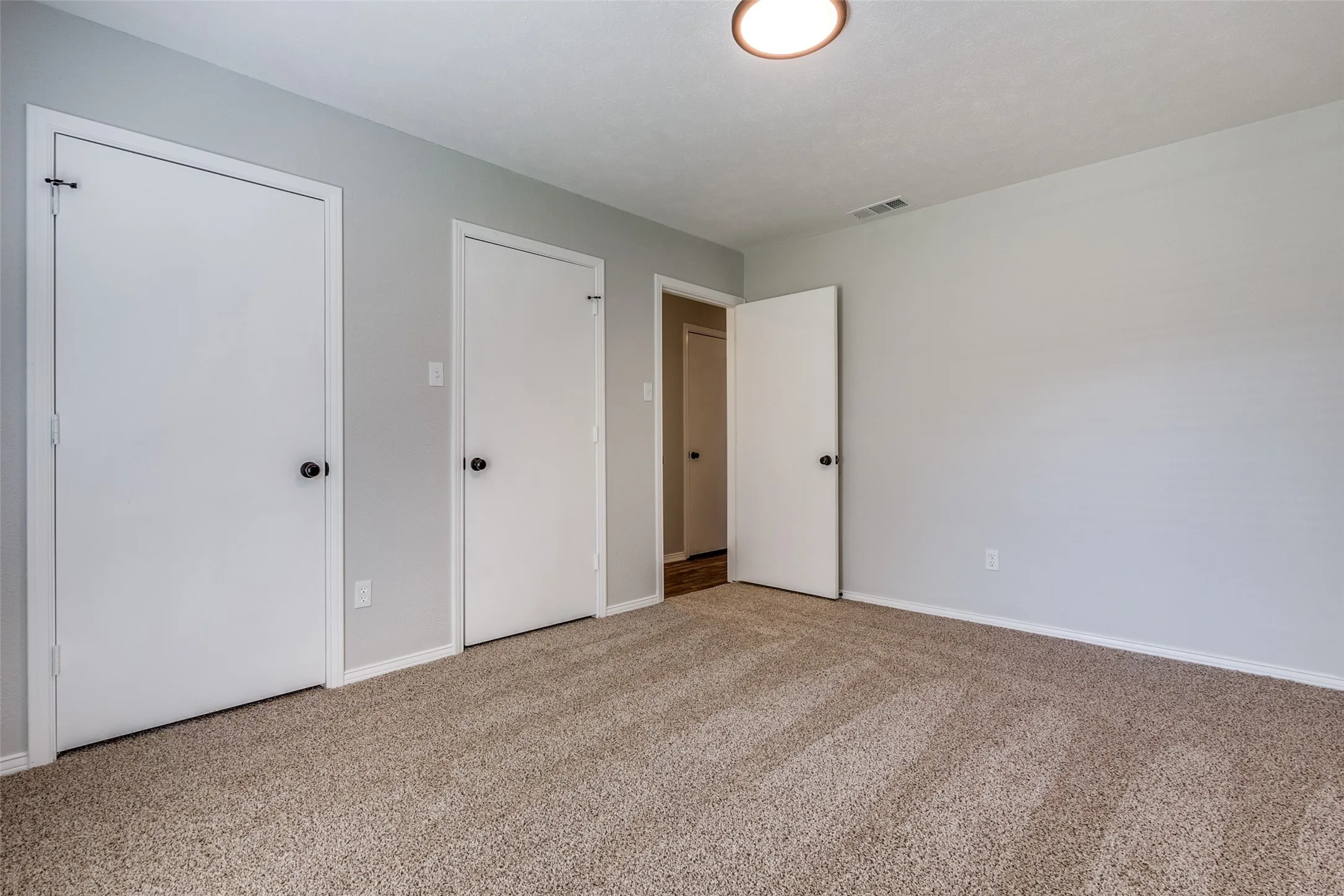 Neutral gray walls complement the textured beige carpet