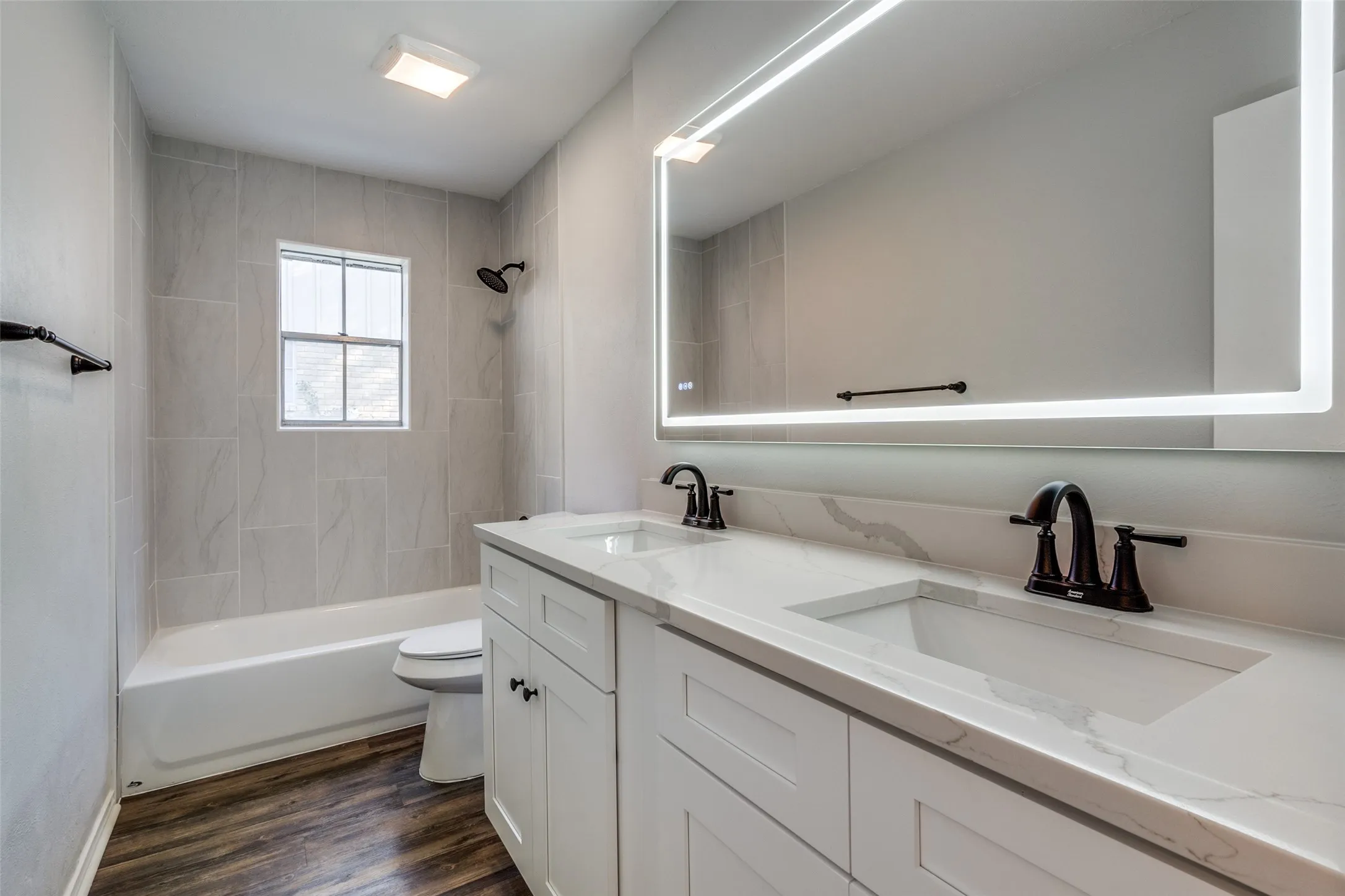 Bathroom featuring a double vanity with stone-finish countertops, integrated sinks, and matte black fixtures
