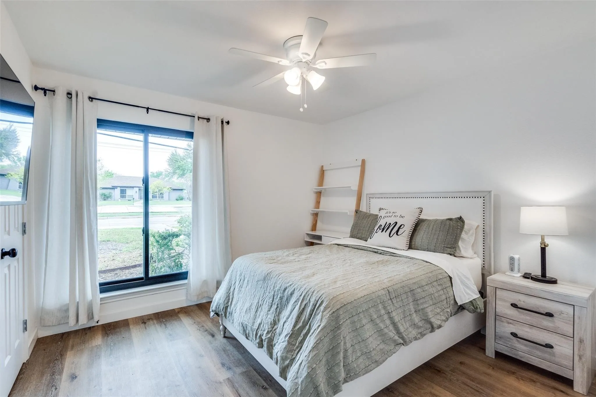 Bright room featuring wood-finish flooring and a ceiling fan