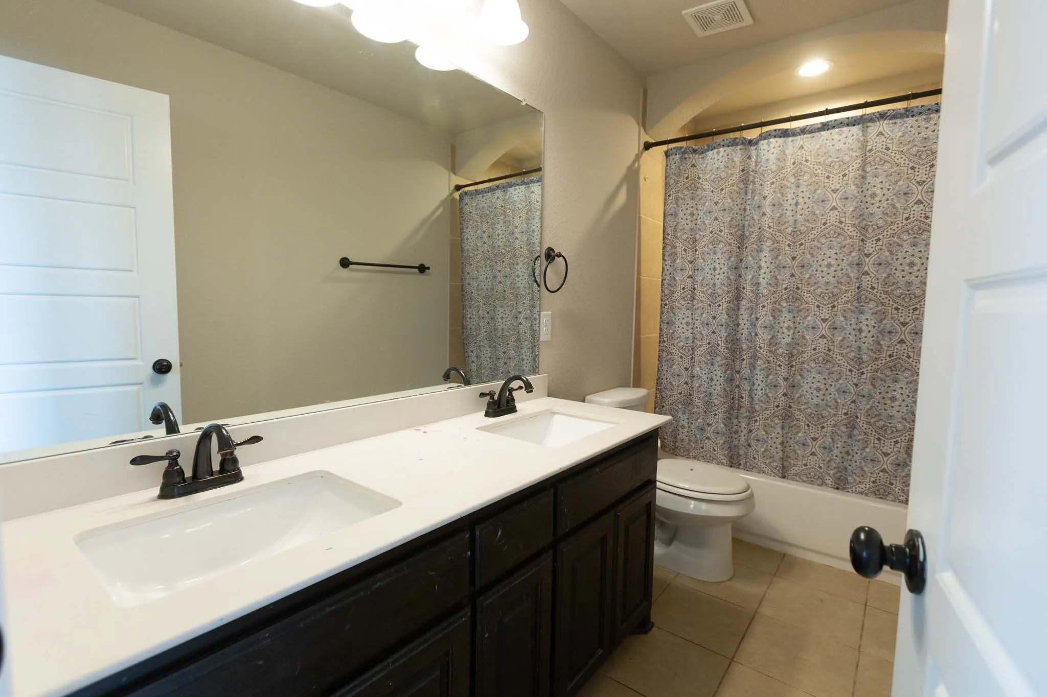 Upstairs Double vanity with dark wood-finish cabinetry and white countertops