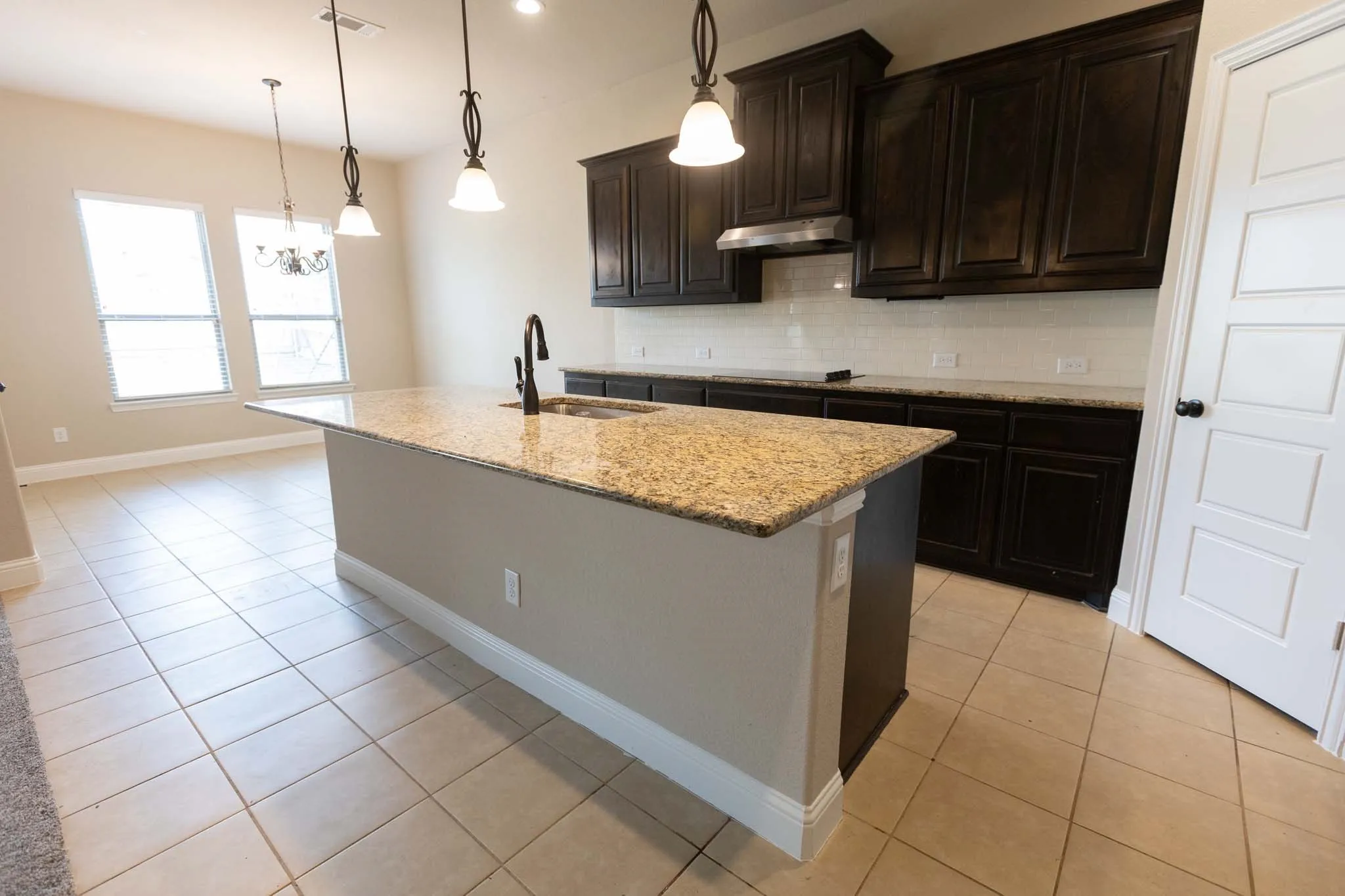 Granite-topped kitchen island with pendant lighting