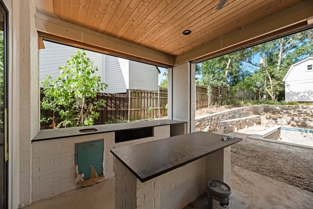 Huge outdoor covered back patio with built-in kitchen and motorized screens to enclose the space.