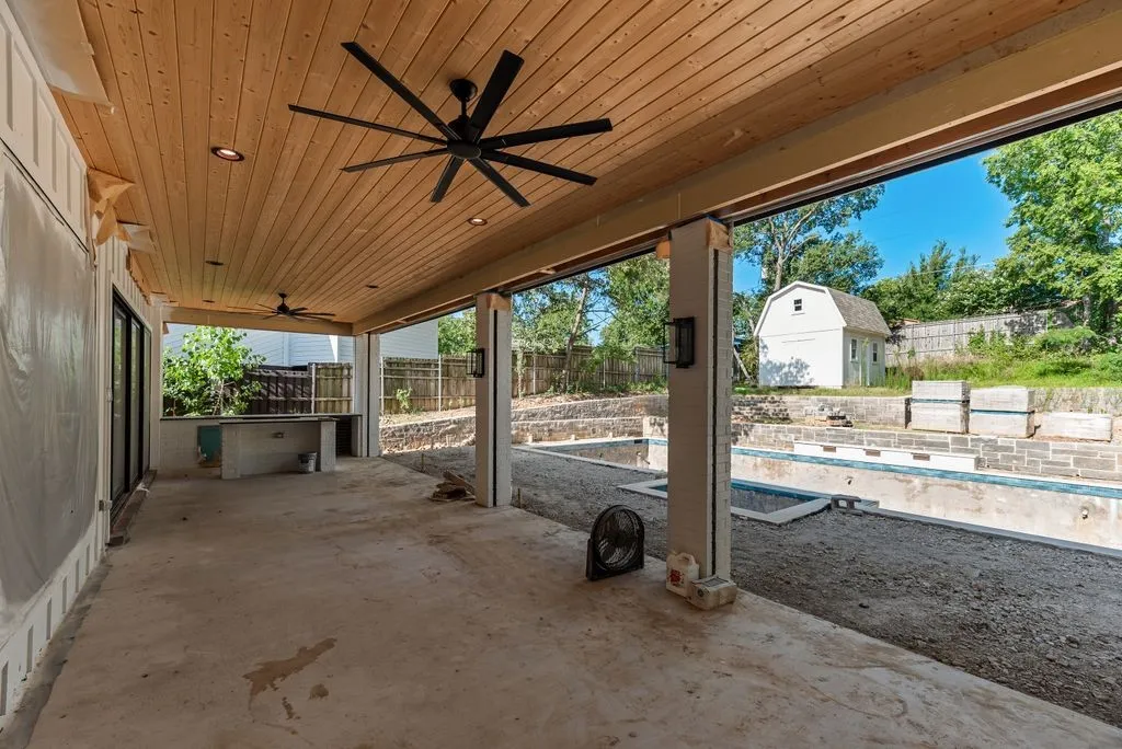 Huge outdoor covered back patio with built-in kitchen and motorized screens to enclose the space.