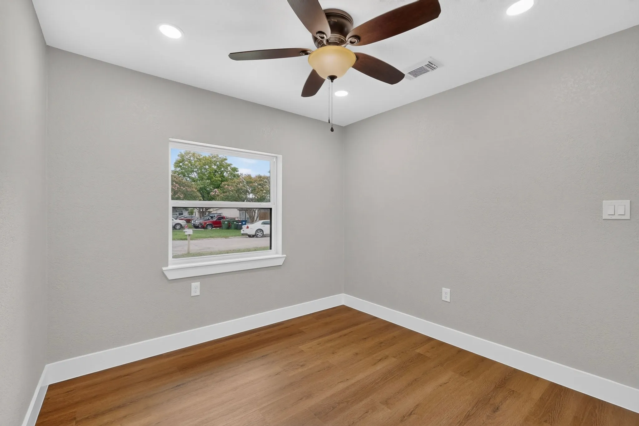 Room featuring wood-finish flooring, recessed lighting, and a ceiling fan with integrated light