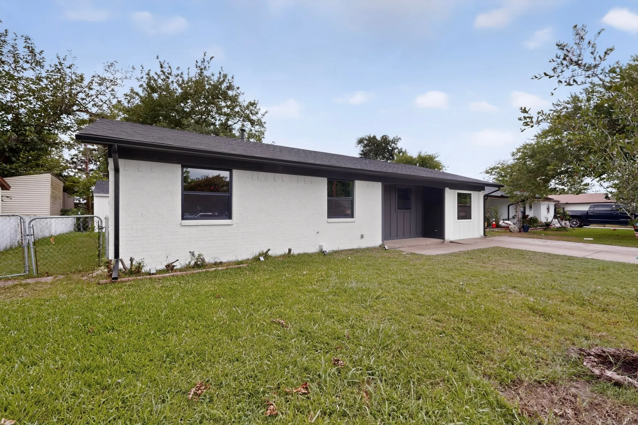 Single-story residence featuring a white brick exterior with dark trim windows