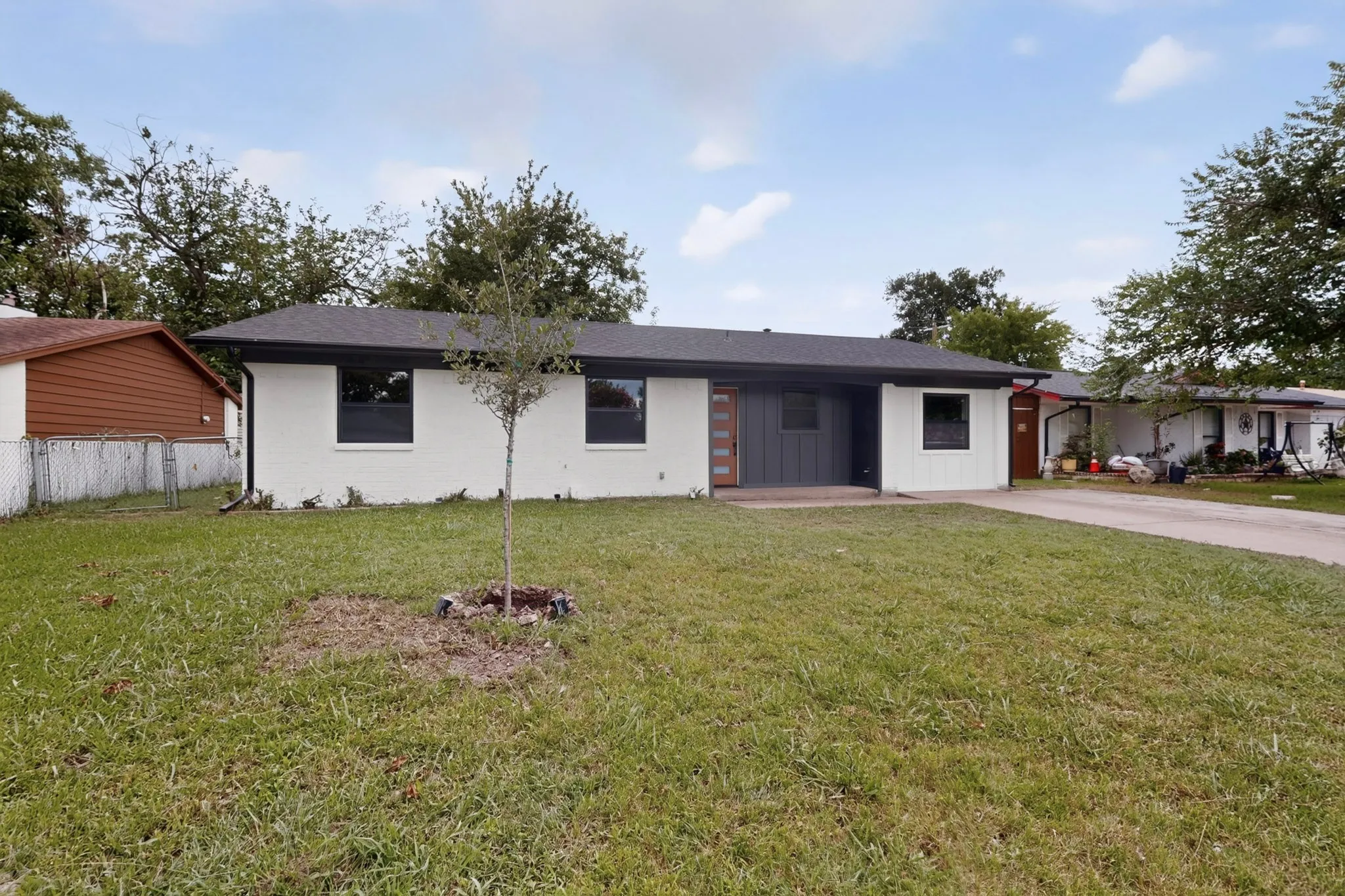 Contemporary single-story residence with a white painted brick exterior and dark trim
