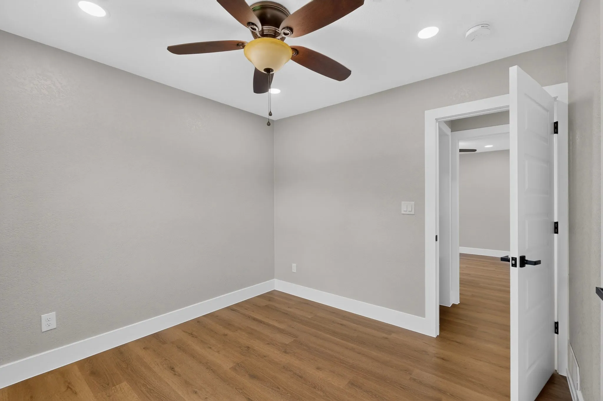 Room featuring wood-finish flooring, recessed lighting, and a ceiling fan