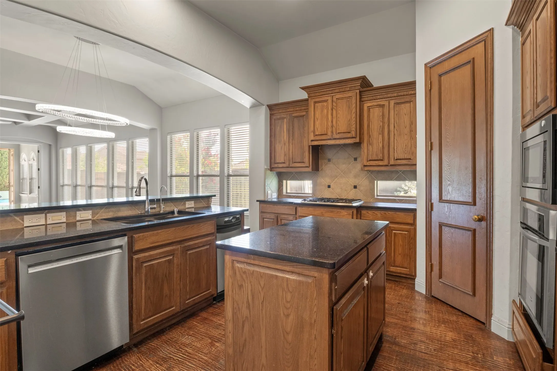 Granite countertops, an island, and gas cooktop.