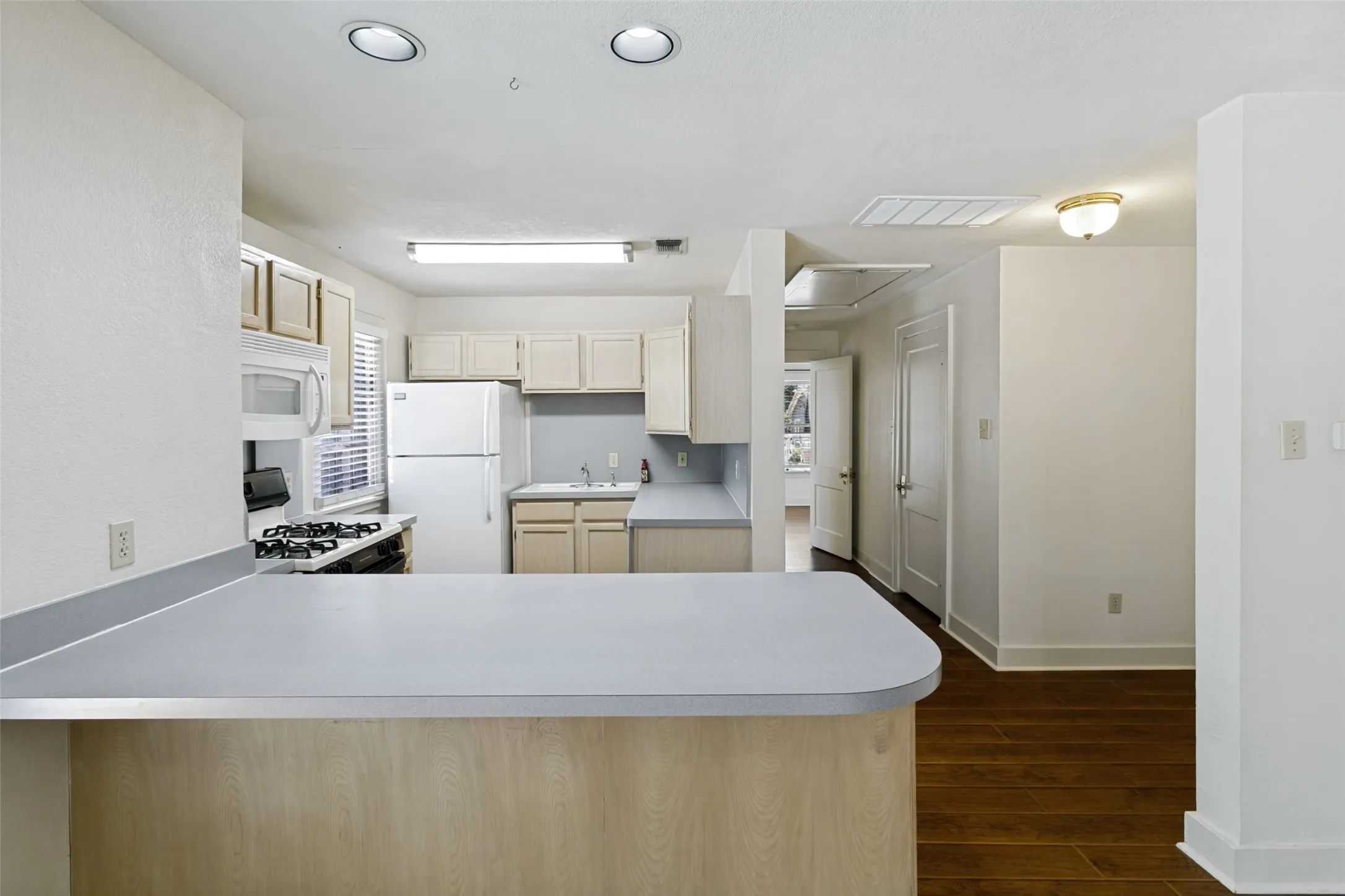 Kitchen with breakfast bar, refrigerator, dishwasher, gas stove and microwave