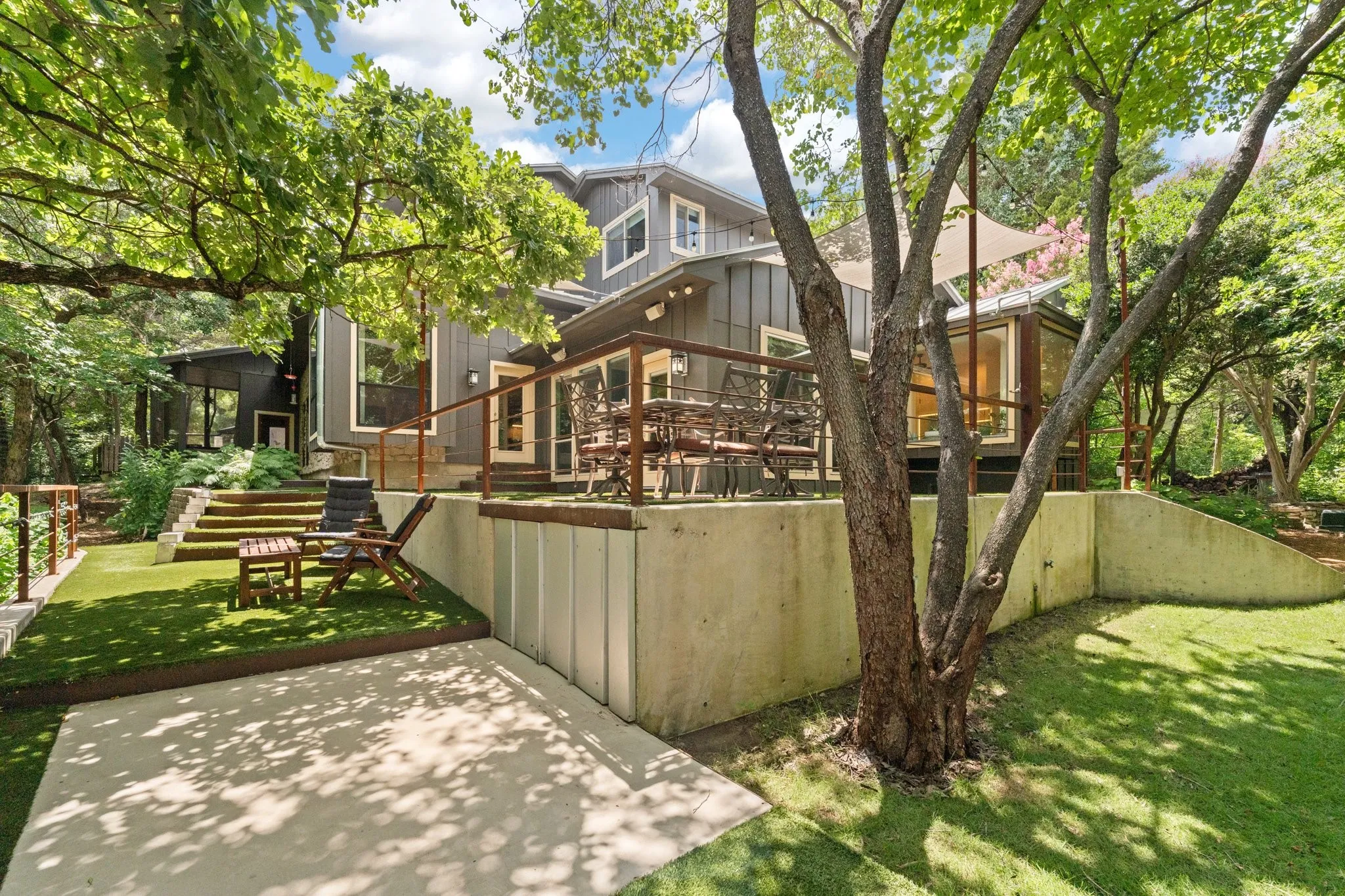  Private backyard featuring a expansive wraparound patio, multiple seating areas, outdoor shower surrounded by lush landscape and an abundance of trees, you will feel like you are immersed in your own private nature park