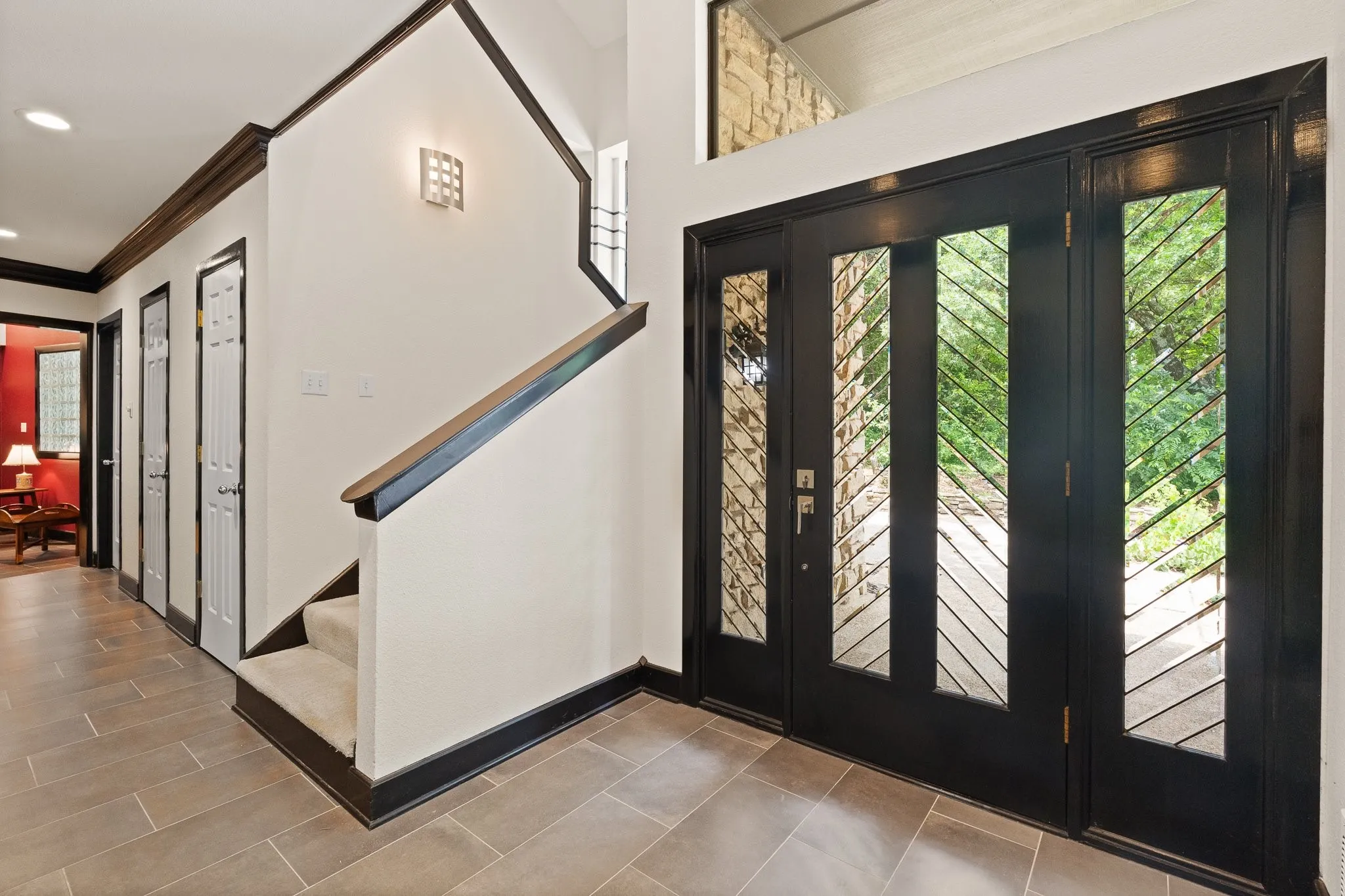 Large, spacious entryway featuring a oversized door with decorative glass inserts