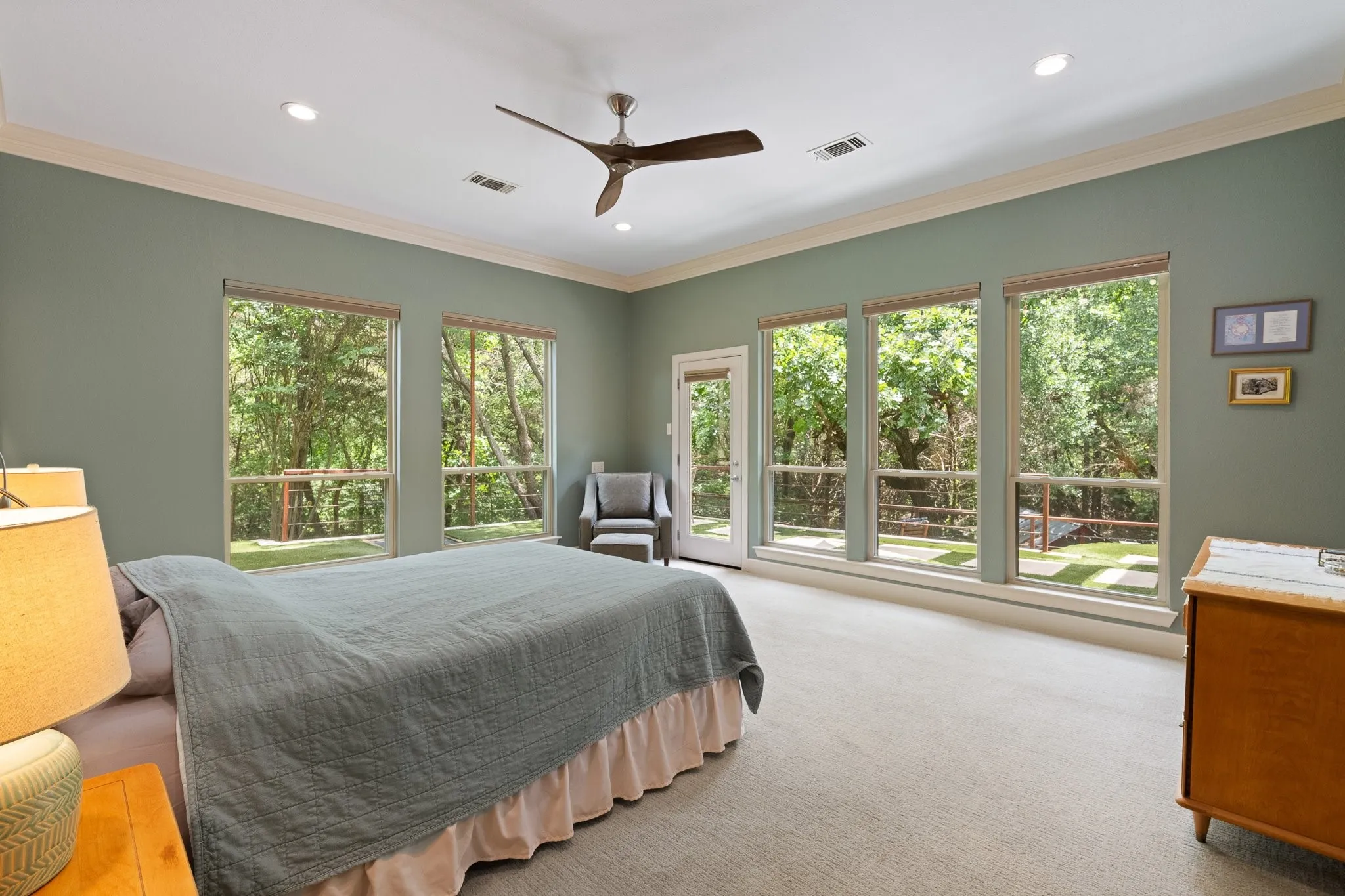 Spacious primary suite with panoramic views and door leading outside to the expansive patio area, this room offers plenty of natural sunlight but shades when needed