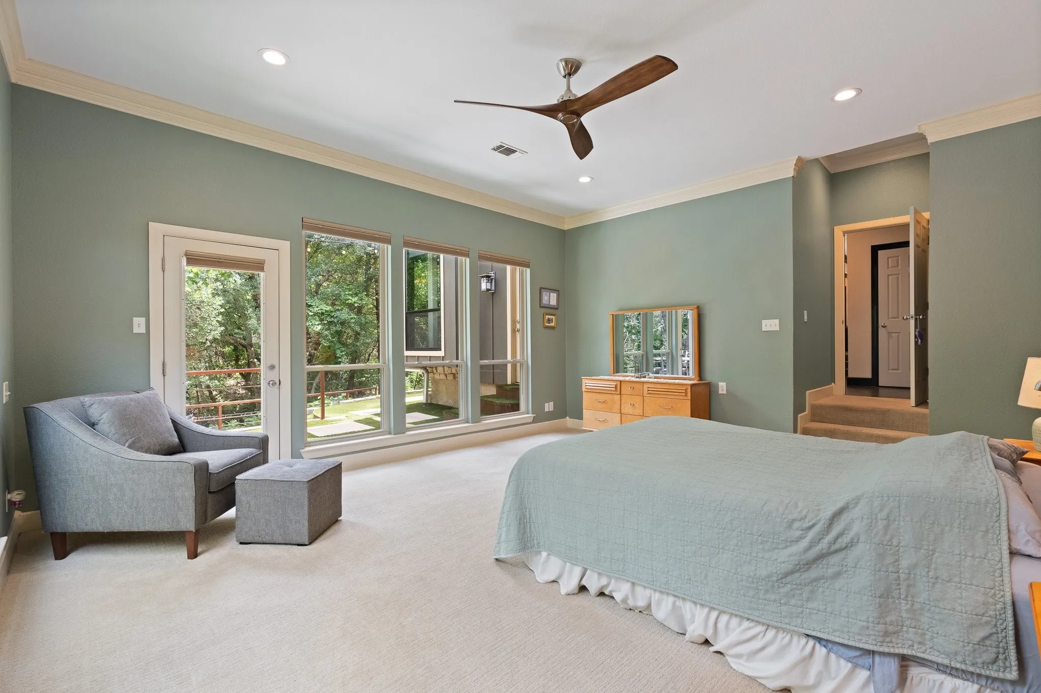 Primary bedroom features large windows and entry door leading to the backyard oasis