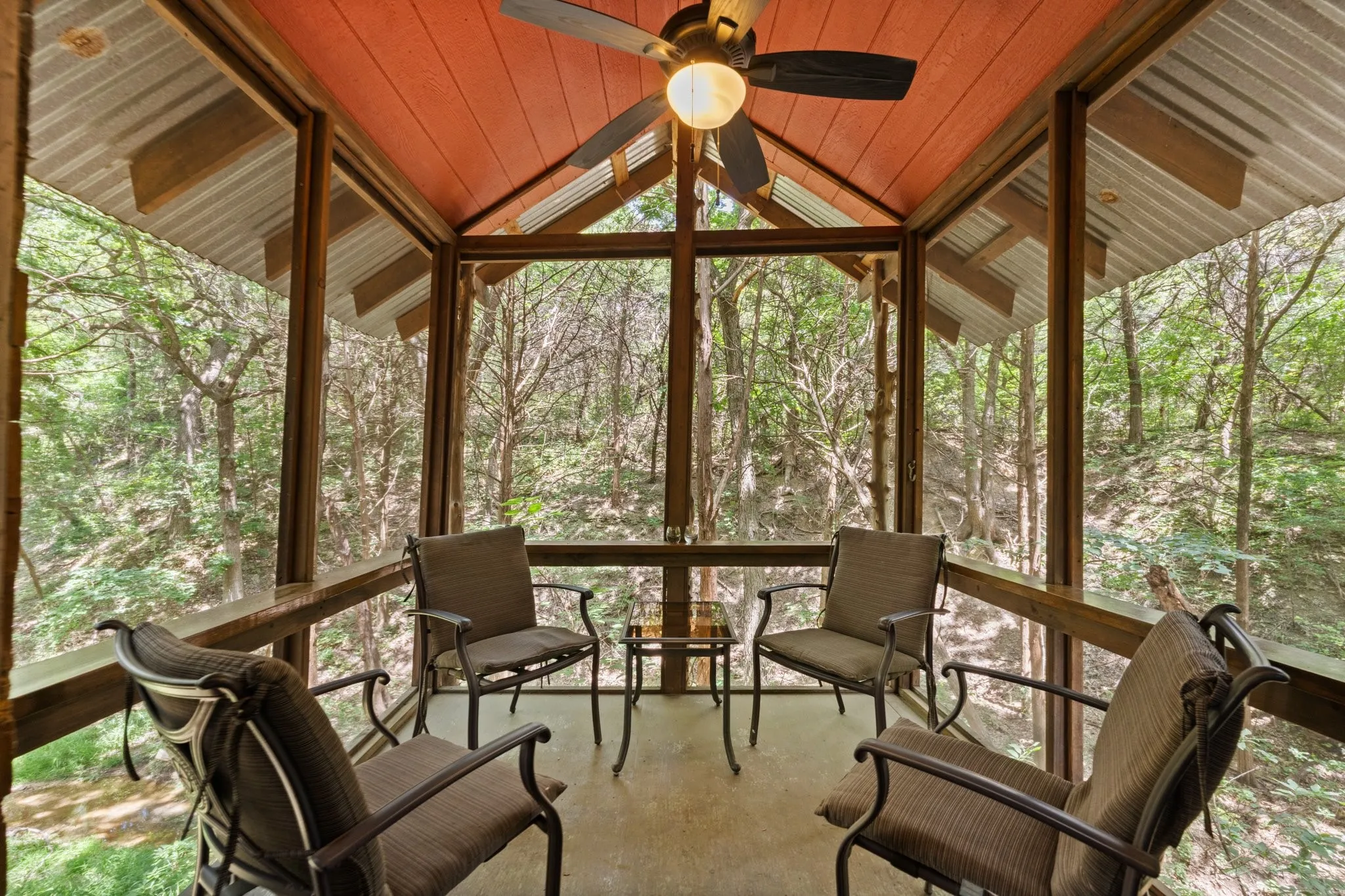 Screened porch featuring a metal roof, vaulted wood-paneled ceiling with fan and electricity. Enjoy time with family and friends any time of the day, immerse yourself in nature without the pesky mosquitos